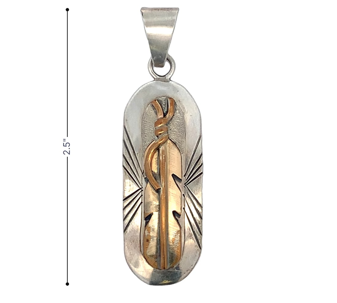 vintage Navajo sterling silver pendant with a 12K gold-filled feather by artist Lee Bennett.: classic Lee Bennett 12K GF feather pendant on a 22 inch sterling silver chain. The long oval sterling background measures 2 inches by 3/4 inch and the 12K GF intricate feather motif measures 11/2 inch