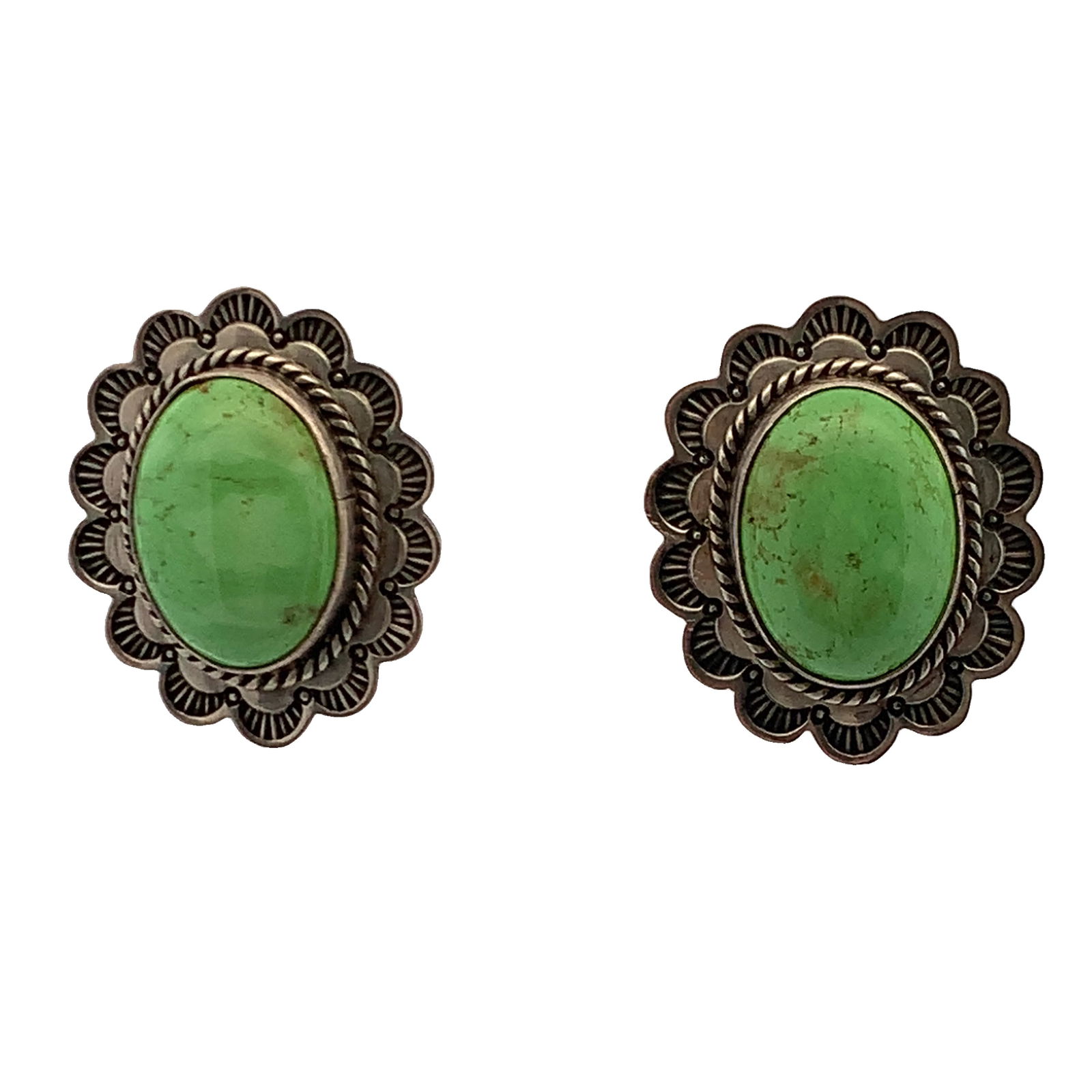 Navajo sterling silver and green turquoise "concho style" post earrings.: Navajo sterling silver and green turquoise "concho style" post earrings. The design, featuring an oval green turquoise stone set within a scalloped, stamped silver border, is characteristic of traditi