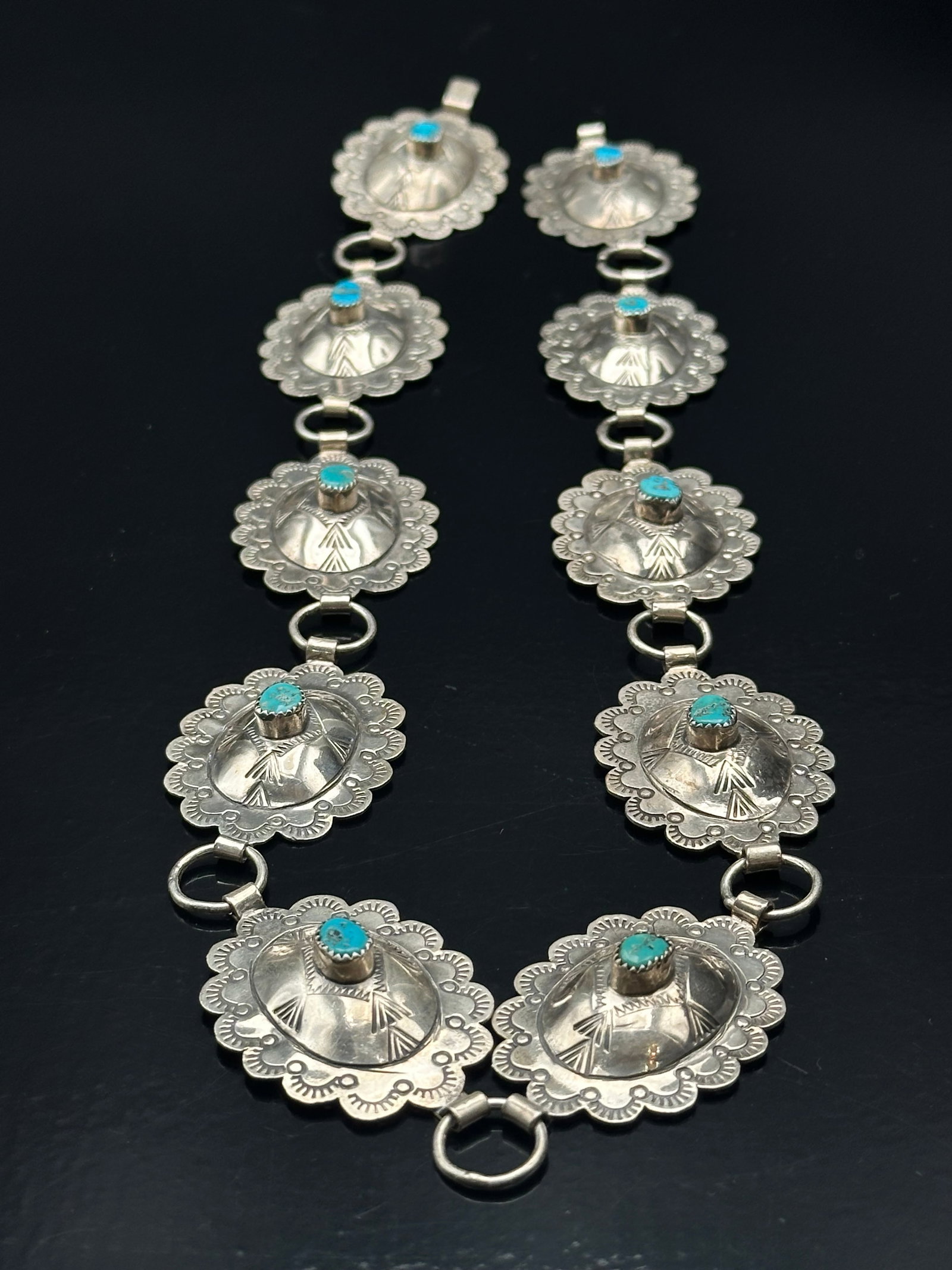 Bennie Ration Navajo Sterling Silver & Turquoise Concho Belt, 106g: Exceptional hand-stamped Navajo concho belt crafted in sterling silver and signed by Bennie Ration, a renowned Native American silversmith. Each scalloped concho features intricate stampwork and a cen