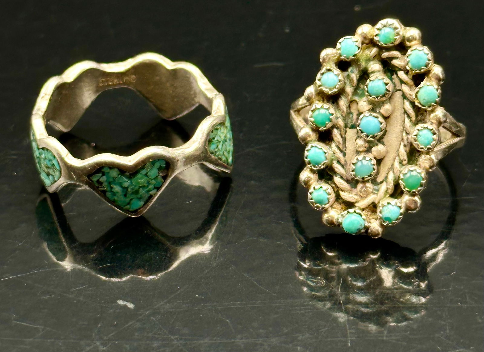Vintage Navajo Sterling Silver Turquoise Rings Lot, Cluster & Heart Inlay, 8g: Pair of vintage Navajo sterling silver turquoise rings. One features a classic cluster design with small turquoise stones set in a floral pattern, accented with rope and leafwork details. The second r