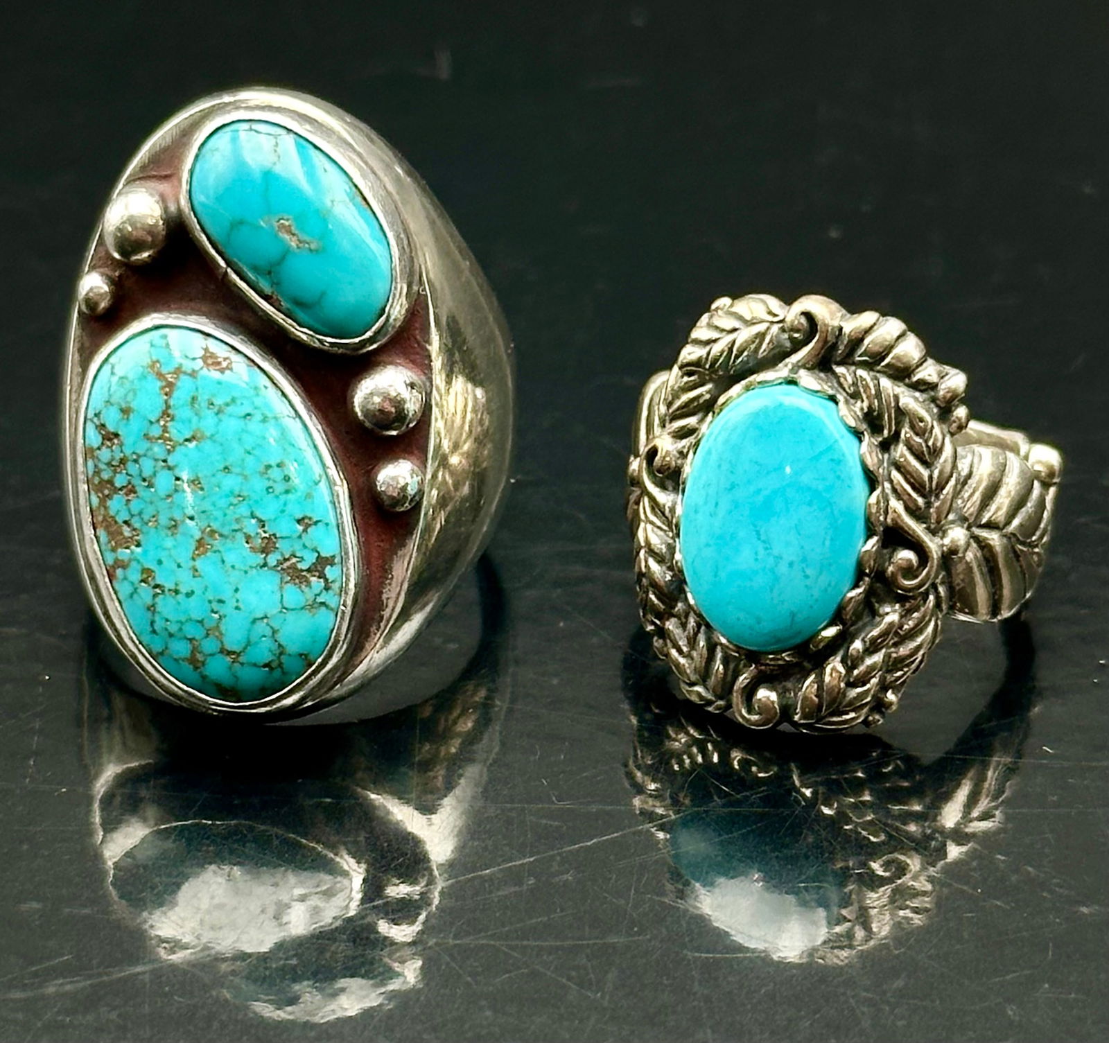 Vintage Navajo Sterling Silver Turquoise Rings Lot, Oval & Leaf Design, 43g: Two striking vintage Navajo sterling silver turquoise rings. The first features a bold double-stone design with rich blue matrix turquoise and silver bead accents. The second has a detailed leaf and s