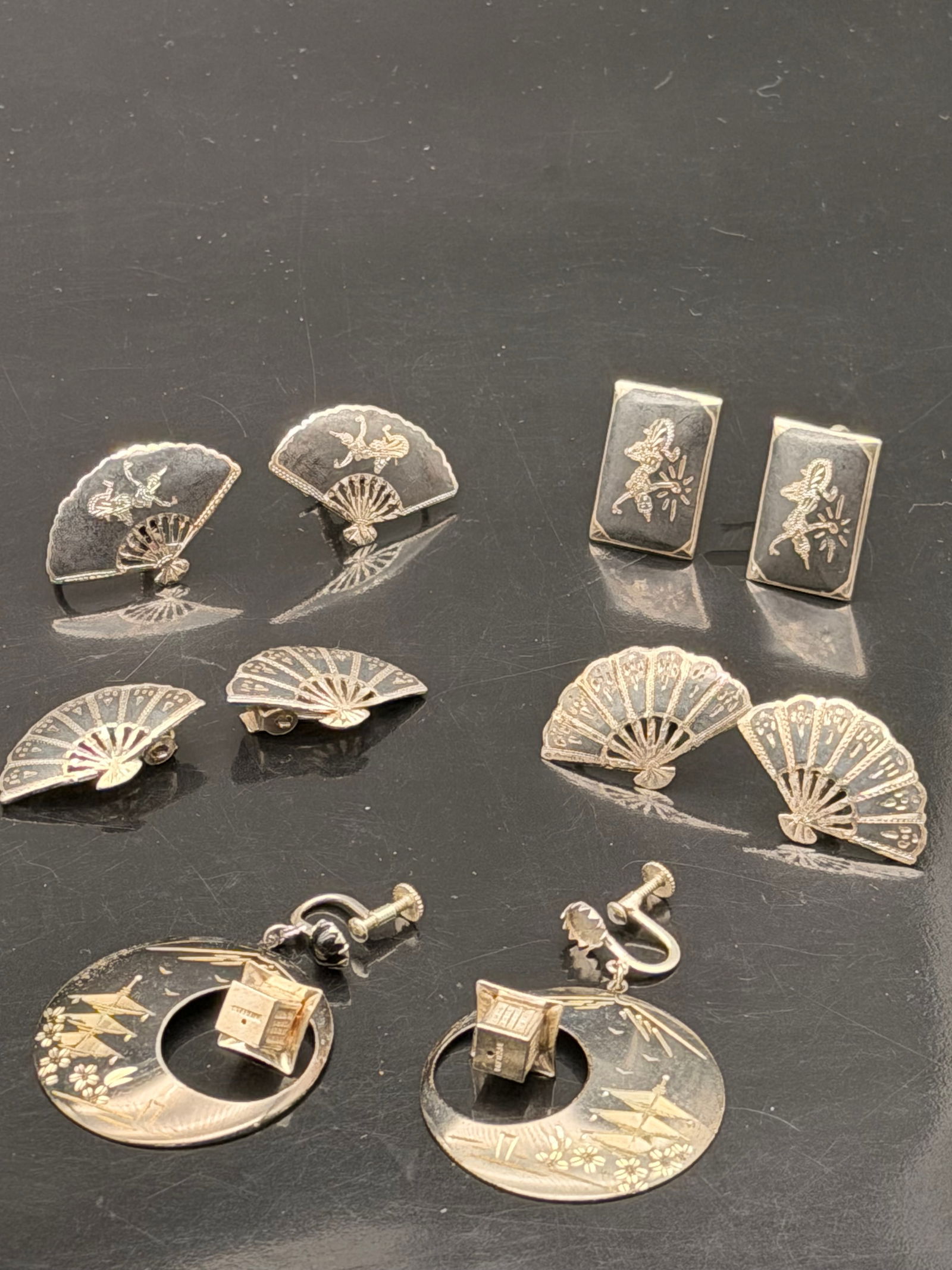 Vintage Damascene Earring Lot – Fans & Japanese Scenic Designs – 40g: Collection of vintage damascene earrings featuring classic Japanese-style designs. Includes multiple screw-back fan earrings with gold floral and bird inlays, rectangular scenic earrings, and a large
