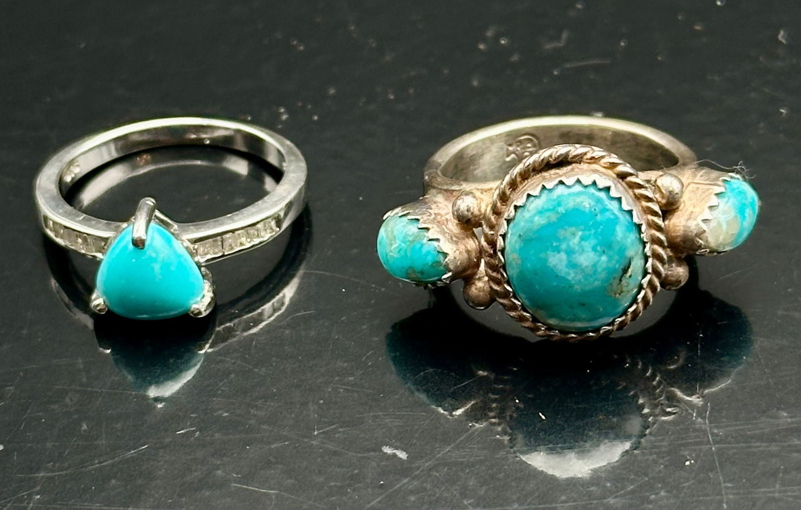 Sterling Silver Turquoise Rings Lot – Sleeping Beauty & Modern Solitaire: Pair of sterling silver turquoise rings. One features three natural Sleeping Beauty turquoise stones in traditional Navajo-style silverwork with bead and rope detailing, size approx. 8. The second rin
