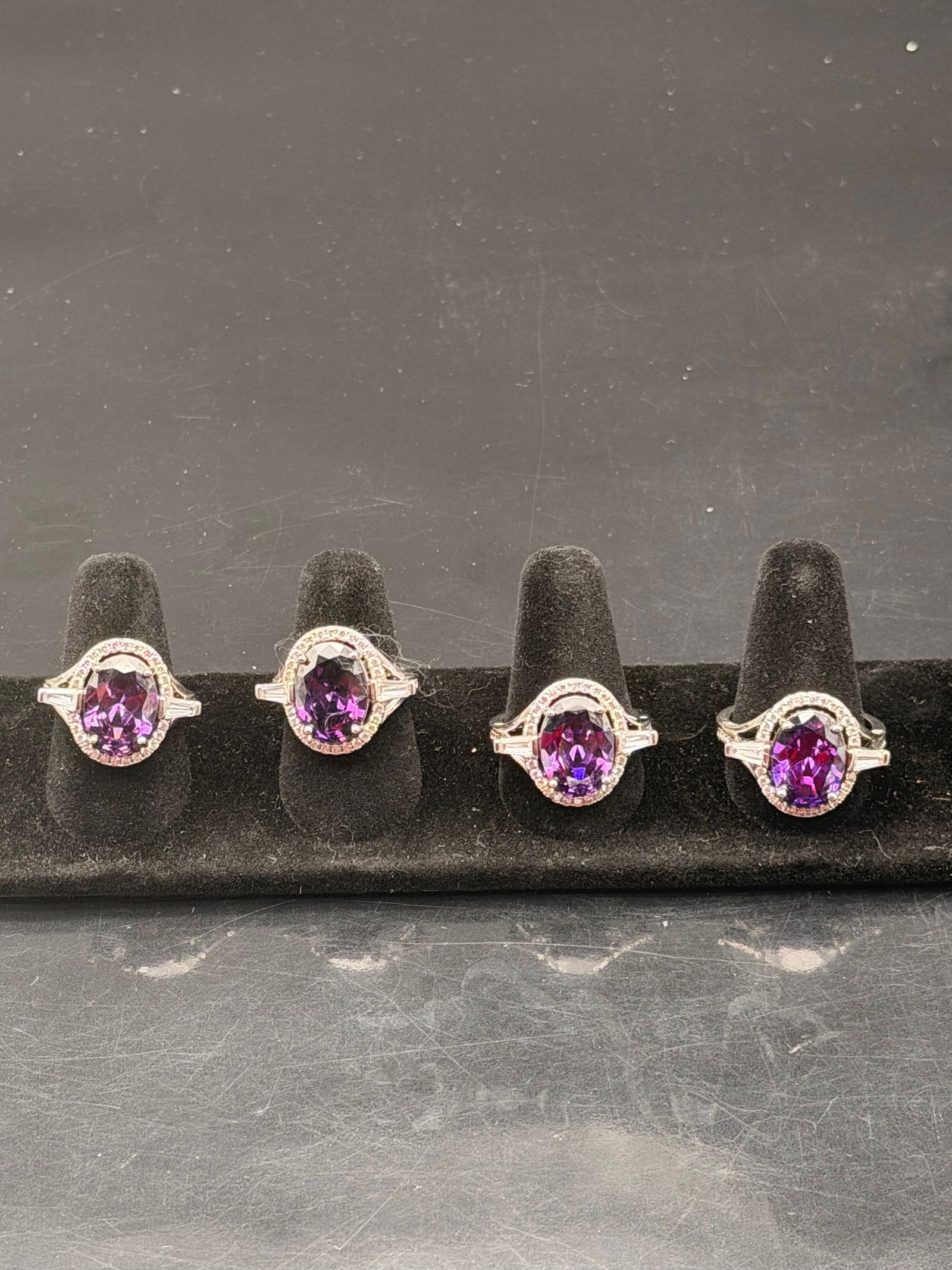Amethyst CZ Silver-Tone Ring Lot – Oval Cut Halo Design (4 Rings): Elegant 4-piece jewelry set featuring oval-cut purple cubic zirconia stones surrounded by sparkling clear halo accents. Each ring is silver-tone with a brilliant high-polish finish and identical gemst