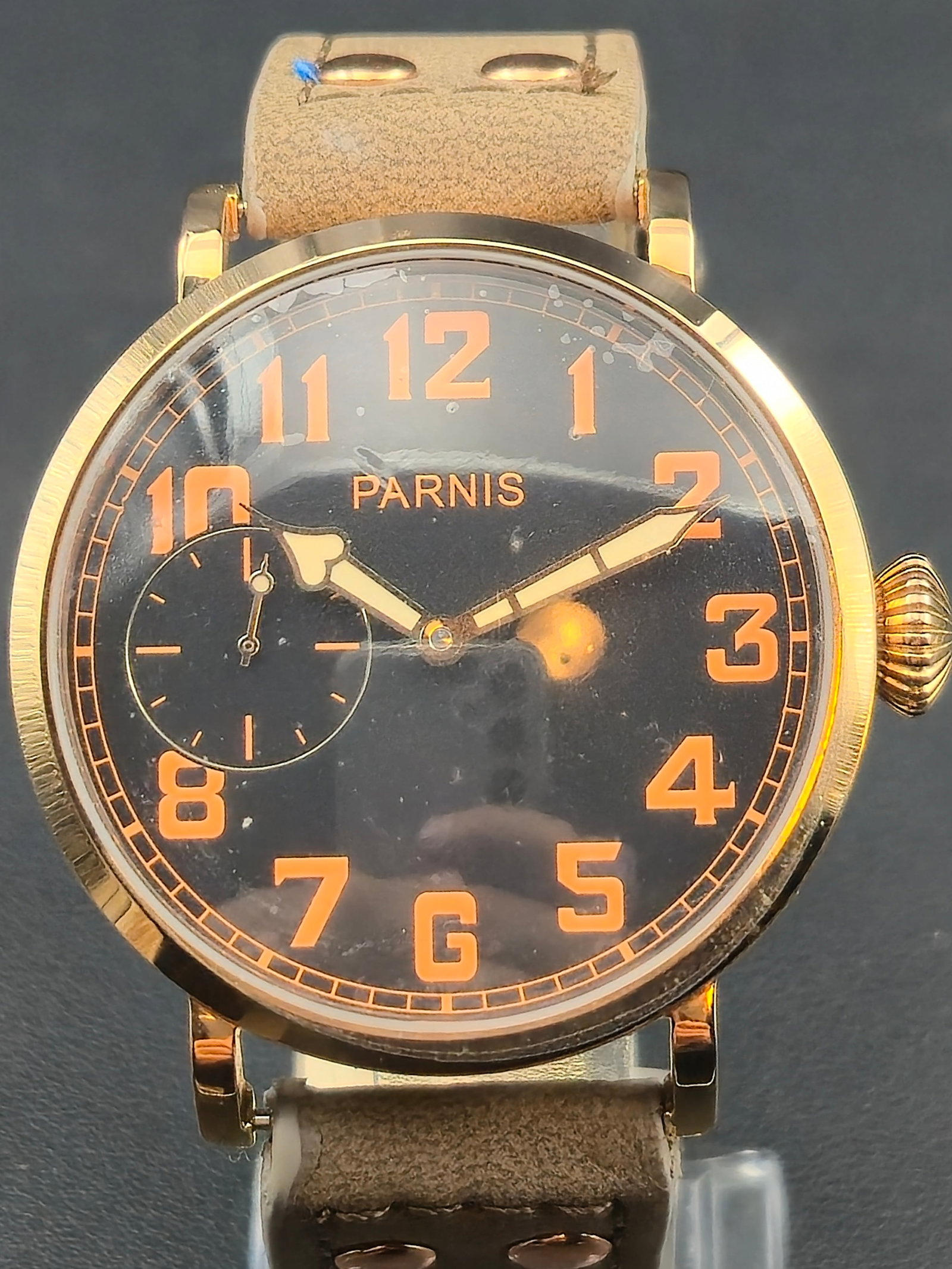 Parnis Manual Wind Rose Gold 40mm Pilot Style Watch – NOS: This new old stock Parnis manual wind pilot-style wristwatch features a rich black dial with bold orange Arabic numerals and a small-seconds subdial at 9 o’clock. The rose-gold-tone stainless case m