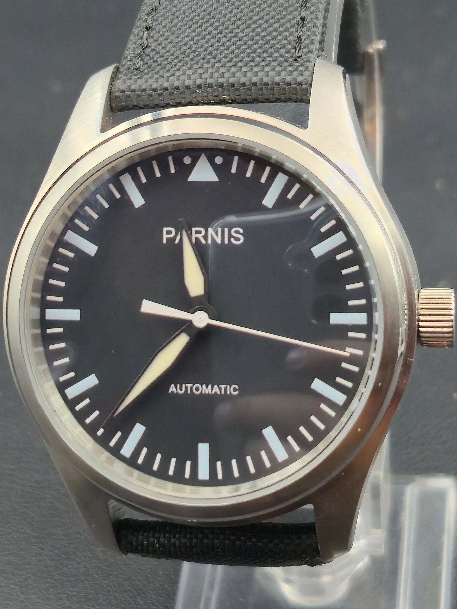 Parnis Automatic Pilot-Style Stainless Steel Watch (41 mm, Display Back, NOS): Unworn Parnis Automatic wristwatch in near-mint NOS condition, inspired by classic pilot and field designs. The minimalist black dial features luminous hands and hour markers, enclosed in a brushed st