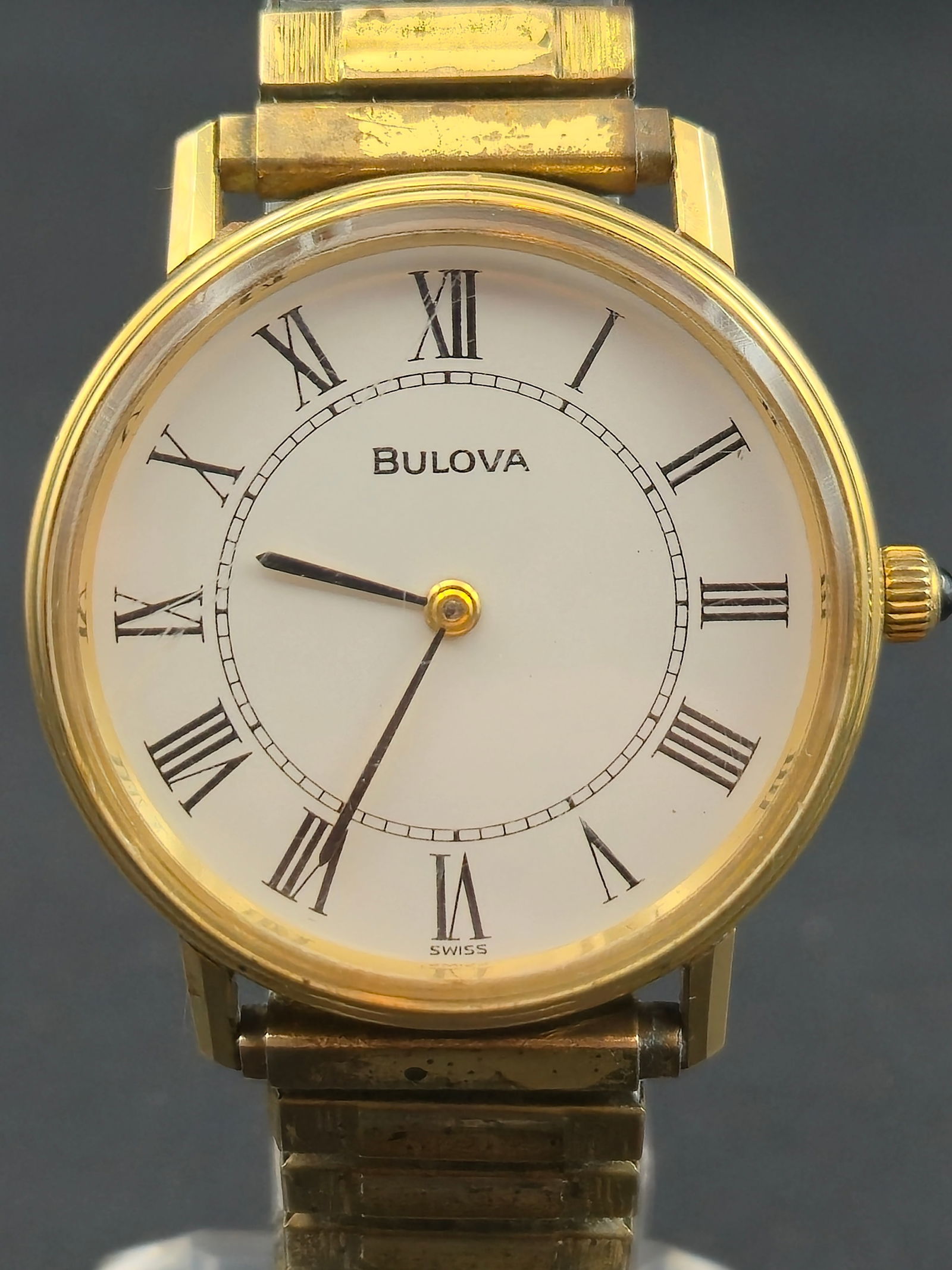 Bulova Swiss 17J Mechanical Gold-Tone Roman Dial Watch (Cal. 11ACAC, 34 mm, Runs): Elegant vintage Bulova Swiss-made mechanical wristwatch featuring a clean white dial with black Roman numerals and minimalist hands. Powered by the Bulova Caliber 11ACAC 17-jewel manual-wind movement,