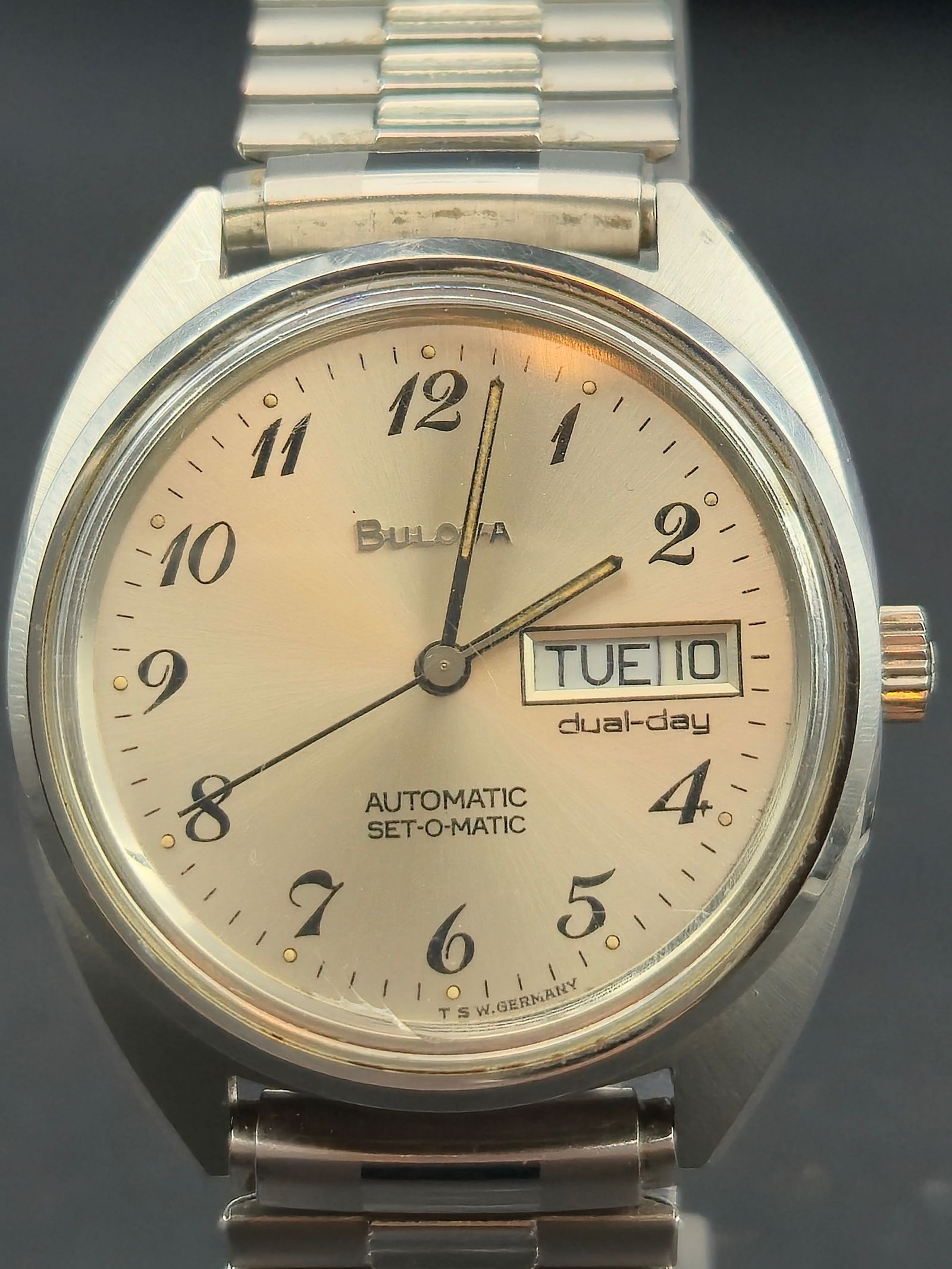 1979 Bulova Set-O-Matic Dual-Day Automatic 35 mm Accutron Crown – Union Engraved: This vintage Bulova Set-O-Matic wristwatch (caseback code N9, denoting 1979) features an automatic movement with dual-day display and silver sunburst dial. The piece retains its signed Accutron tuning