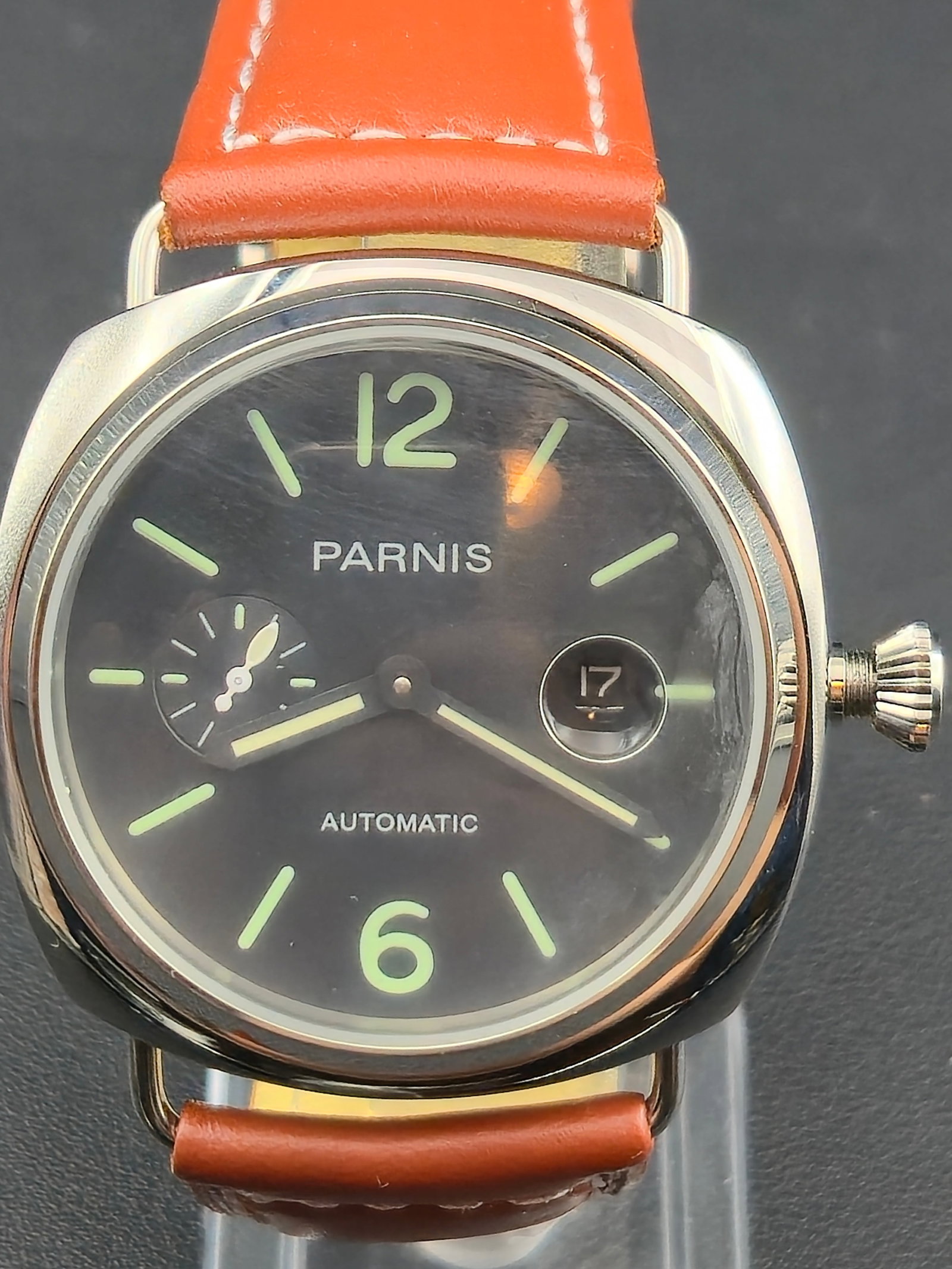 Parnis Automatic 45 mm “Luminor Homage” Small Seconds Date – NOS: This Parnis automatic wristwatch features a bold 45 mm stainless-steel case, matte black dial with luminous markers, small-seconds subdial at 9 o’clock, and a date magnifier at 3 o’clock. It’s p