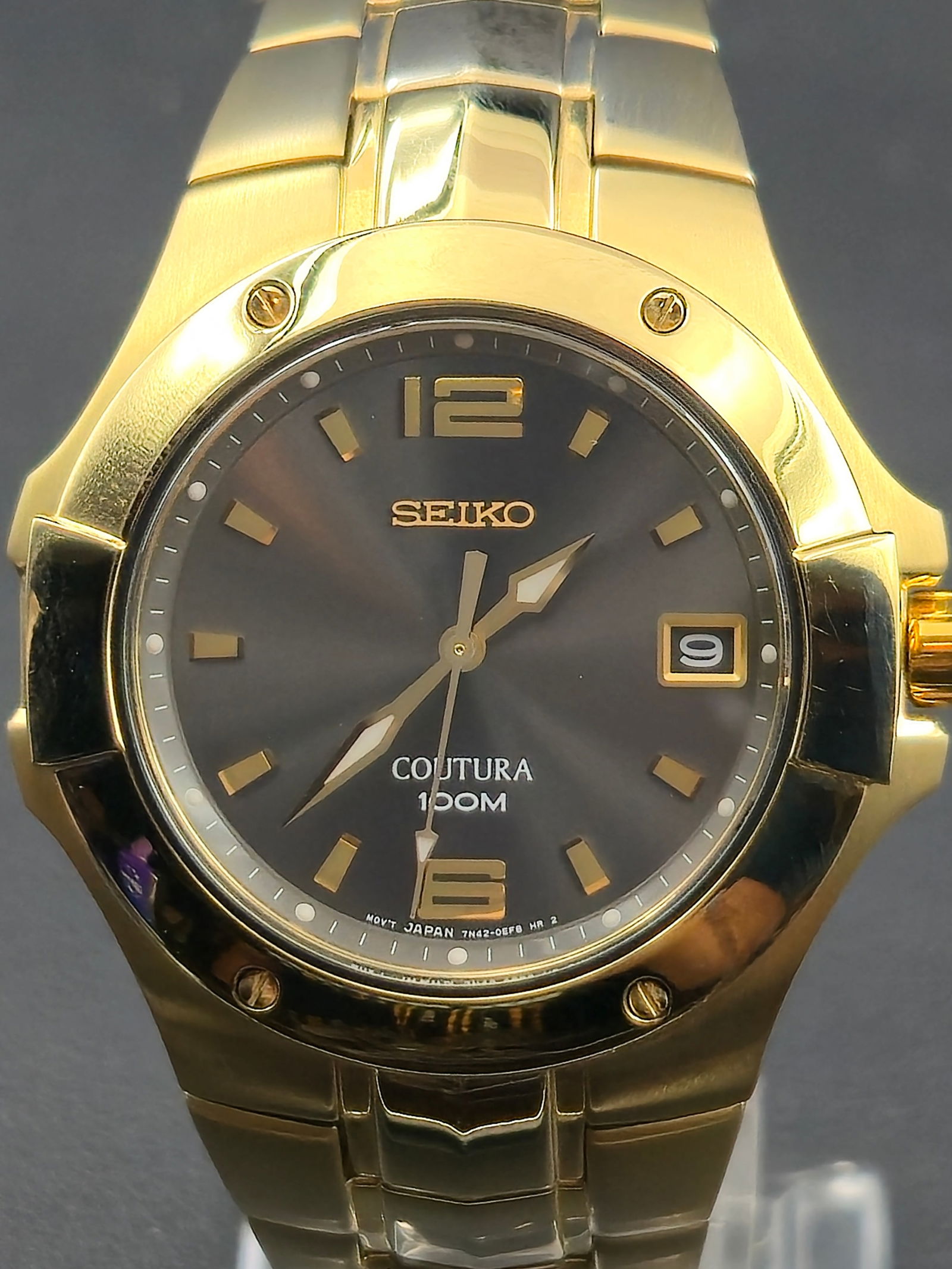 Seiko Coutura 7N42 Quartz 40 mm Gold-Tone Sapphire 100M – Mint, New Battery: This Seiko Coutura wristwatch features a refined gold-tone stainless-steel case and bracelet with a sapphire crystal and 100-meter water resistance. The gray sunburst dial includes a date window at 3