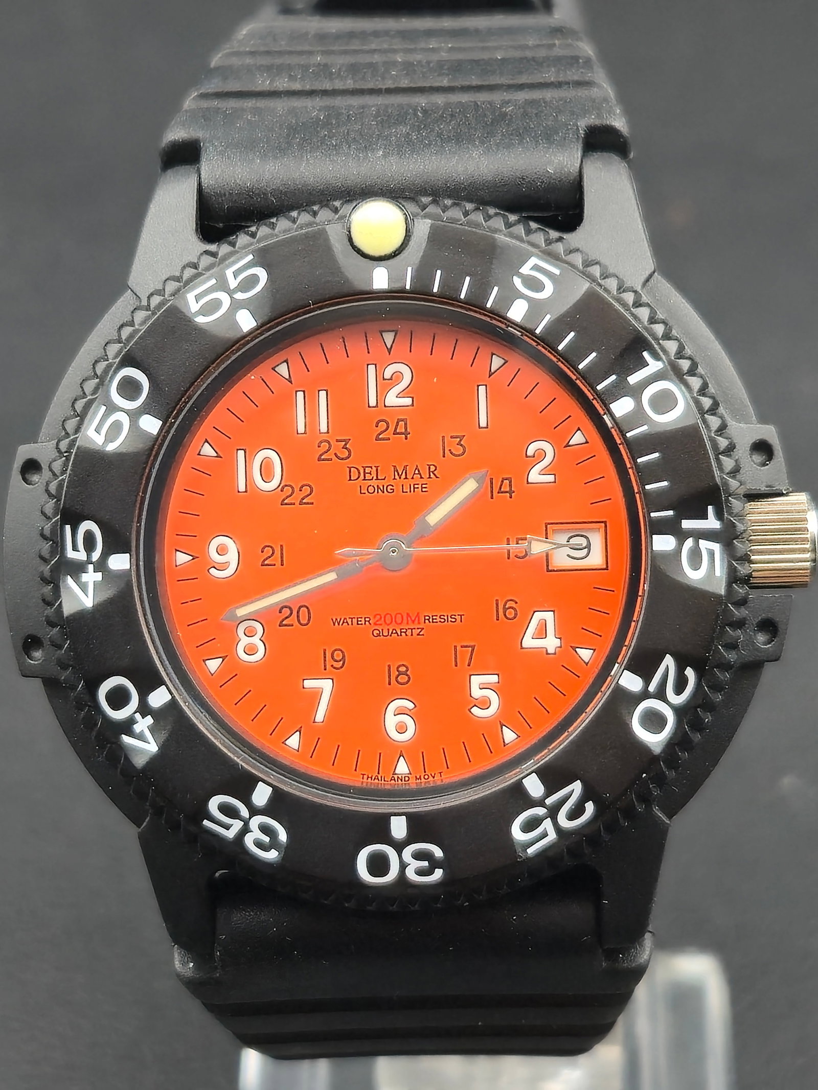 Del Mar Long Life Quartz Diver 200M 44mm Orange Dial NOS Full Set: New-old-stock Del Mar Long Life quartz diver watch featuring a bold orange dial with luminous hands and markers, a unidirectional timing bezel, and rugged black resin case. This model is water-resista