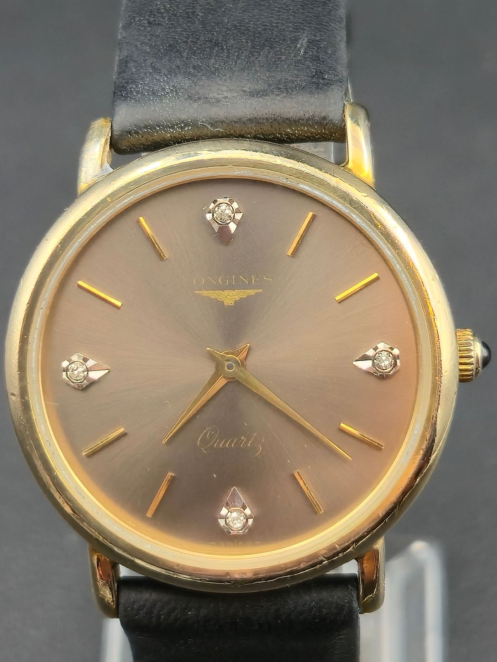 1980s Longines 32mm Gold-Tone Diamond Dial Quartz Watch Swiss Q4775 – New Battery, Runs: Elegant 1980s Longines Swiss quartz wristwatch featuring a refined gold-tone case and a sunburst champagne dial set with four diamond hour markers at 3, 6, 9, and 12 o’clock. Powered by the reliable