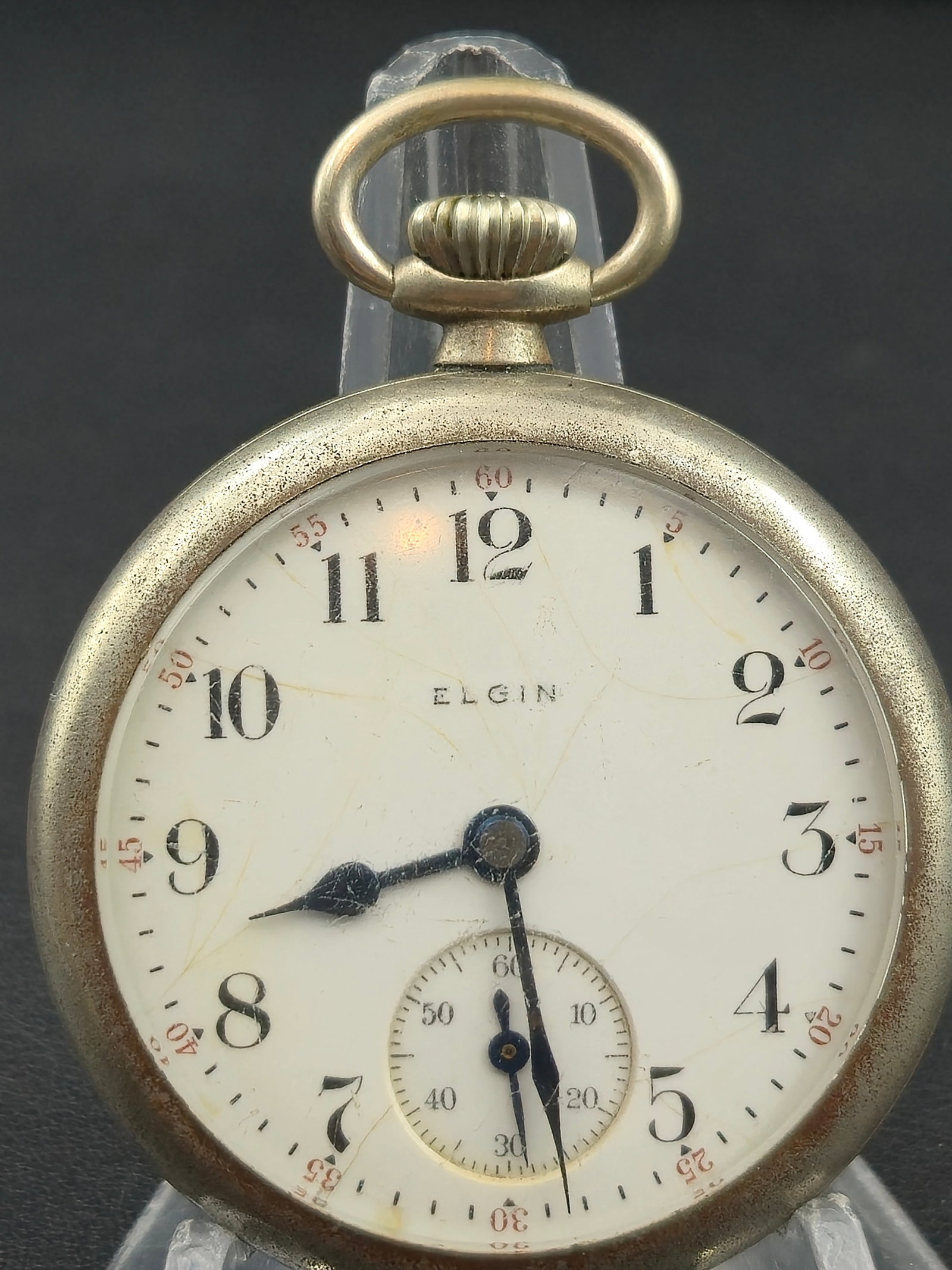 1902 Elgin 7J 12s “Nickeloid Case Elgin” Pocket Watch – Running: Offered is an Elgin 7-jewel pocket watch from circa 1902, housed in its original Keystone Nickeloid open-face case (serial 713605). The white enamel dial shows uniform age cracking but remains fully r
