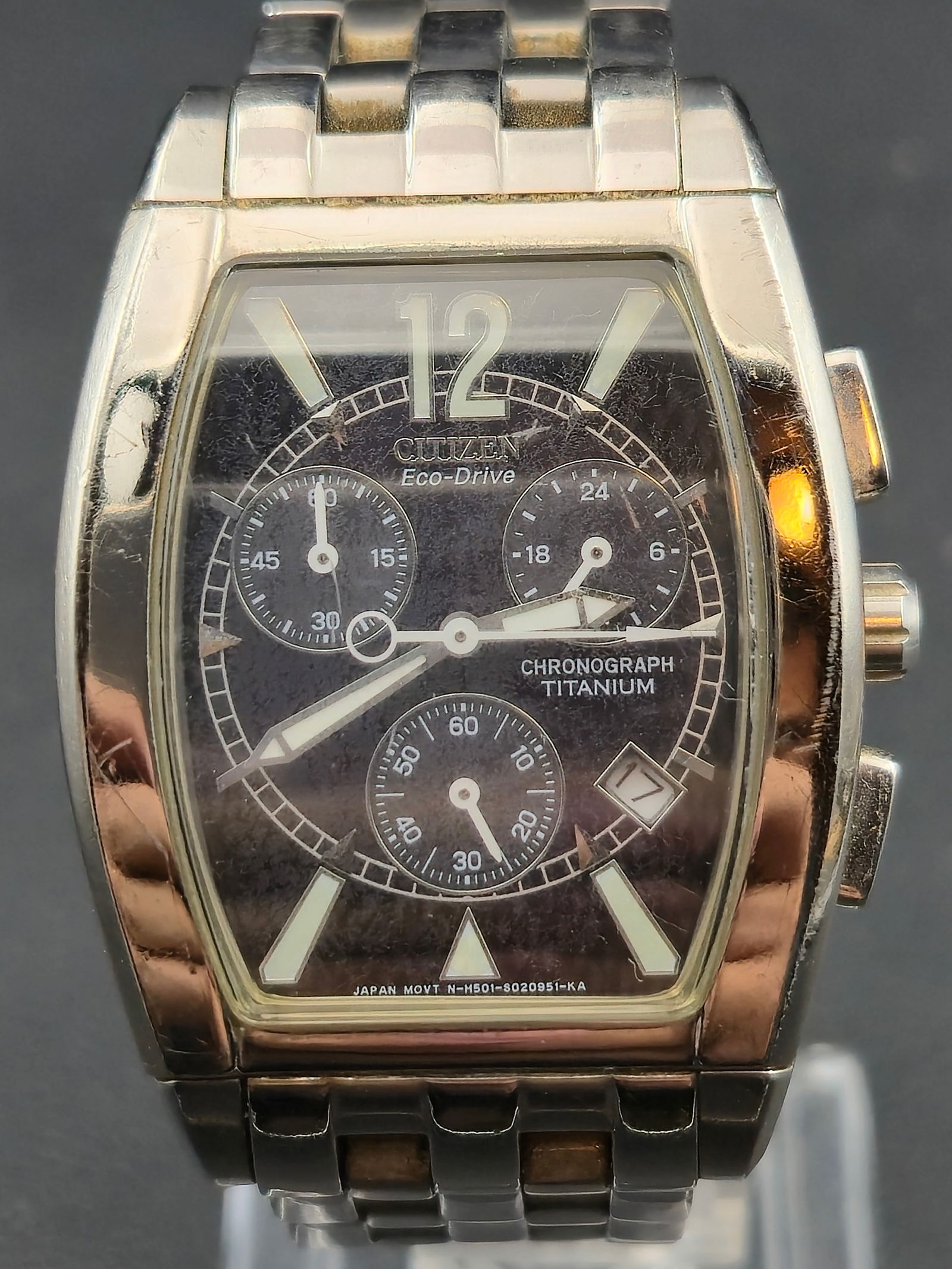 Citizen Eco-Drive Titanium Chronograph 32mm Tonneau Watch – Running and Keeping Time – Japan: Citizen Eco-Drive Titanium chronograph featuring a curved tonneau case, black multi-register chronograph dial, luminous markers, and a titanium finish. Powered by the Citizen H501 solar Eco-Drive move