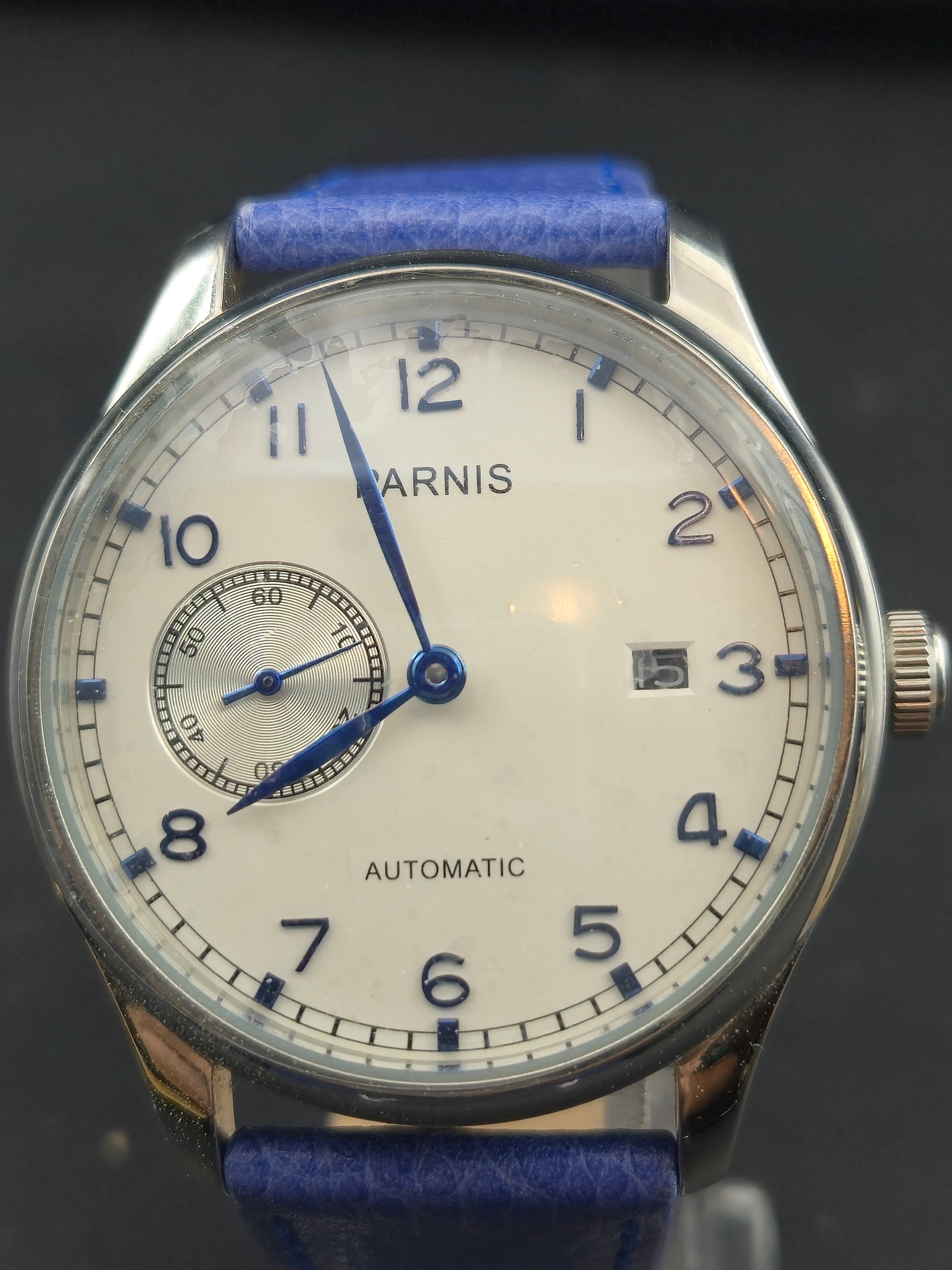 Parnis Automatic 42mm Pilot Dress Watch Small Seconds White Dial Blue Markers NOS Runs: This is a Parnis automatic wristwatch in New Old Stock condition. The watch features a large 42mm polished stainless steel case with exhibition display back, allowing full view of the decorated automa