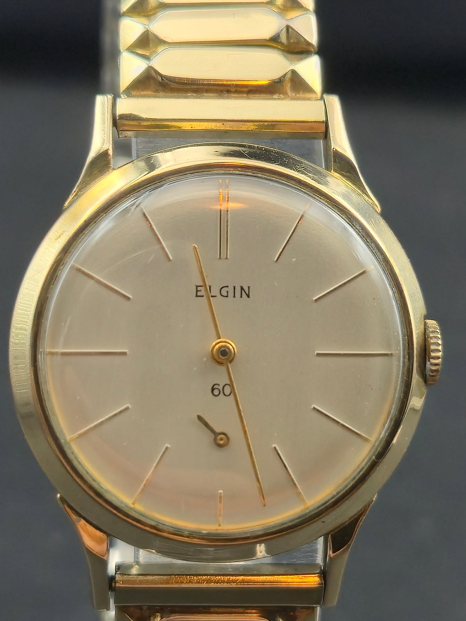 1960s Elgin 30mm 19J Mechanical Dress Watch 10K RGP Bezel – Runs: Vintage 1960s Elgin 19-jewel mechanical dress watch featuring a minimalist silver dial with stick markers and a 60-second subdial. Powered by the Elgin 19J USA movement (Cal. 773), the watch is runnin