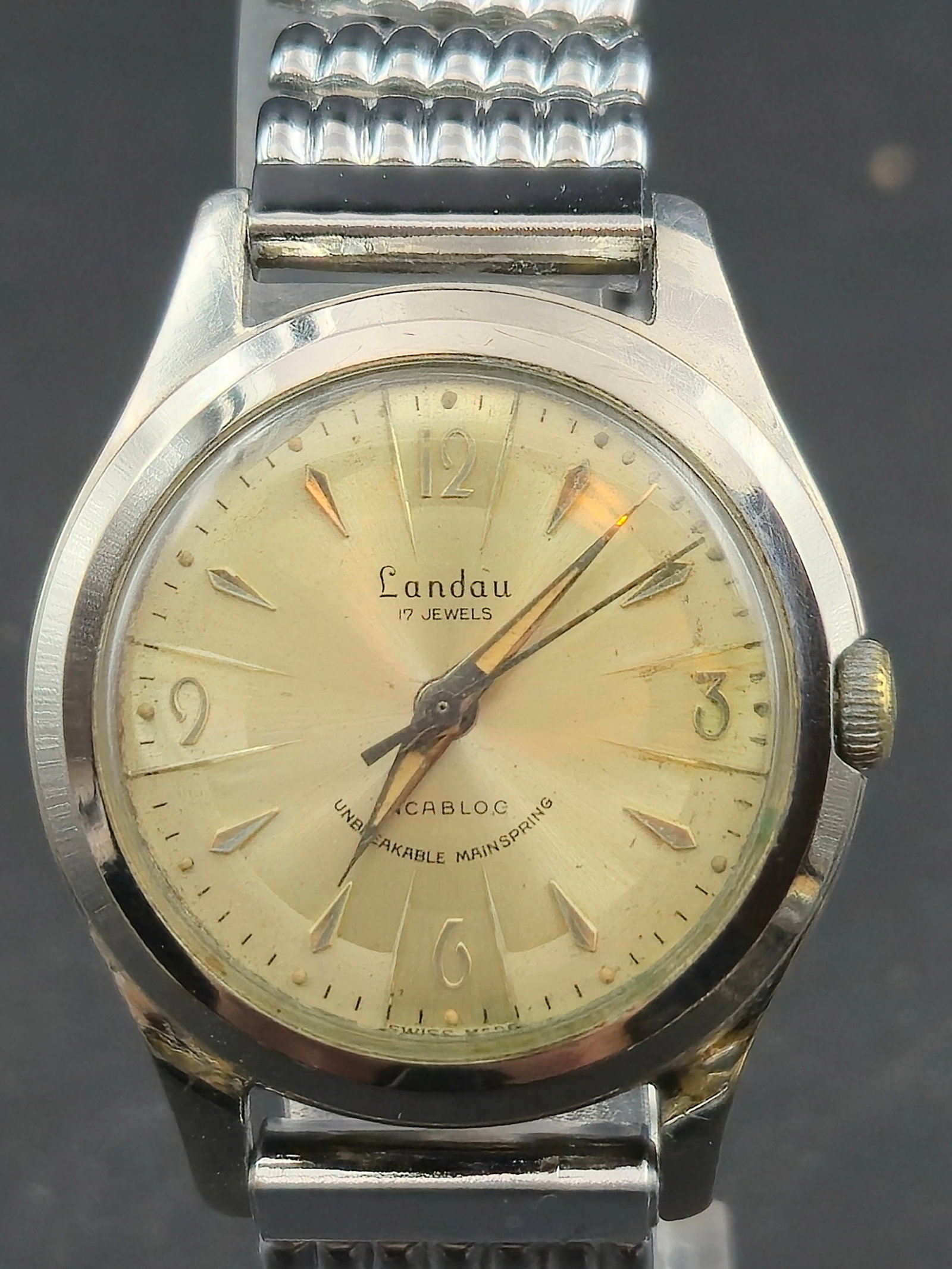 1950s Landau 17 Jewel Incabloc Swiss Watch 32mm Stainless Back Runs Vintage Dress Model: Vintage 1950s Landau 17 Jewel Incabloc wristwatch featuring a gold-tone case, classic champagne sunburst dial with applied markers at the quarters, and an unbreakable mainspring. Powered by a Swiss 17