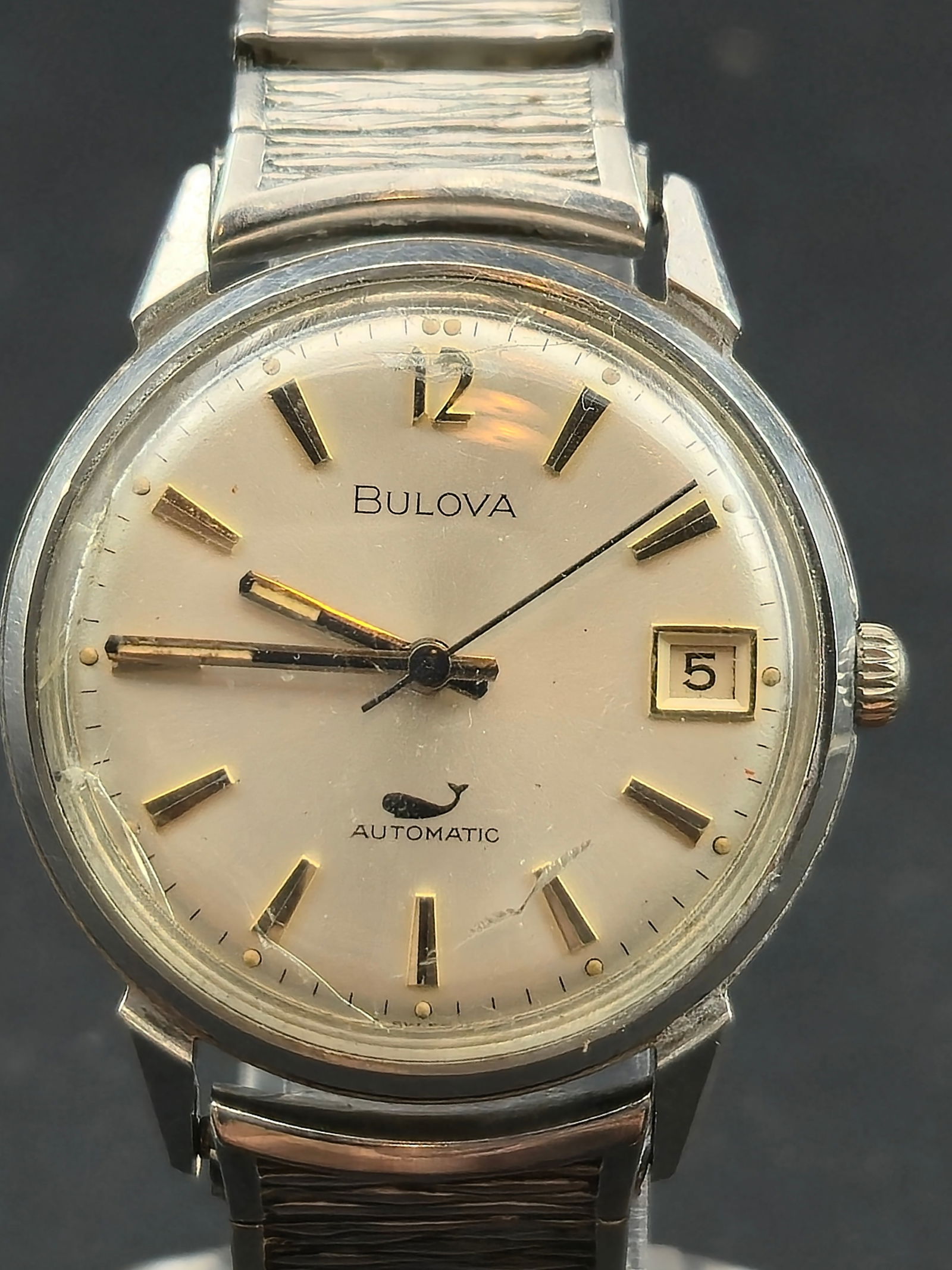 1970 Bulova Automatic Whale Dial 33mm Stainless Steel Ref. 11ANACD – Runs: Vintage 1970 Bulova automatic wristwatch featuring the desirable whale logo dial, date window, and original gold-tone markers. Housed in a stainless steel case with matching vintage Speidel USA bracel