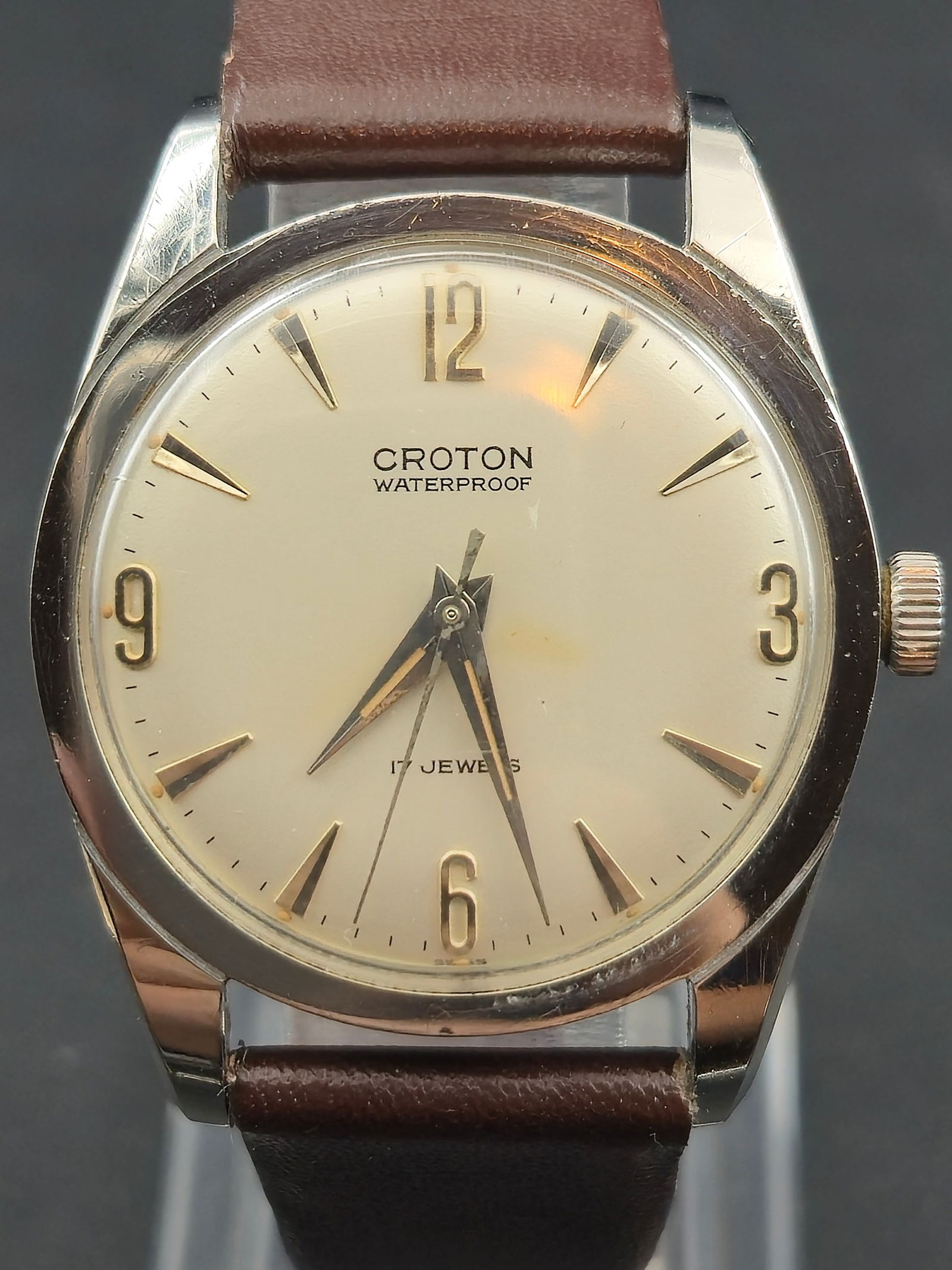1960s Croton Waterproof Stainless Steel Dress Watch 33mm Swiss 17 Jewel Manual Runs: Vintage 1960s Croton stainless steel dress watch with a clean cream dial, applied gold tone numerals at the twelve, three, six and nine positions, and faceted gold tone hour markers. Features original