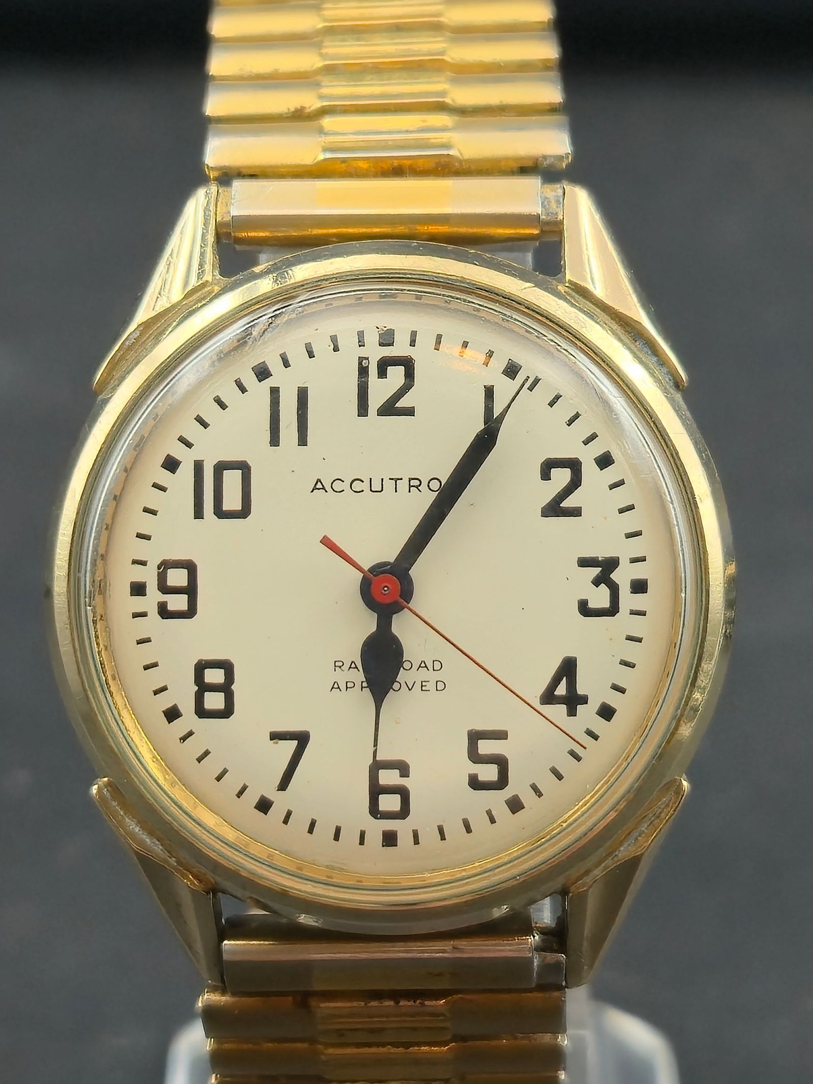 1969 Bulova Accutron 214H Railroad Approved 34mm 10K GF Bezel – Runs Smooth: This 1969 Bulova Accutron Railroad Approved features the desirable white railroad-grade dial with bold black numerals and red sweep hand. Powered by the legendary tuning-fork 214H movement, the watch