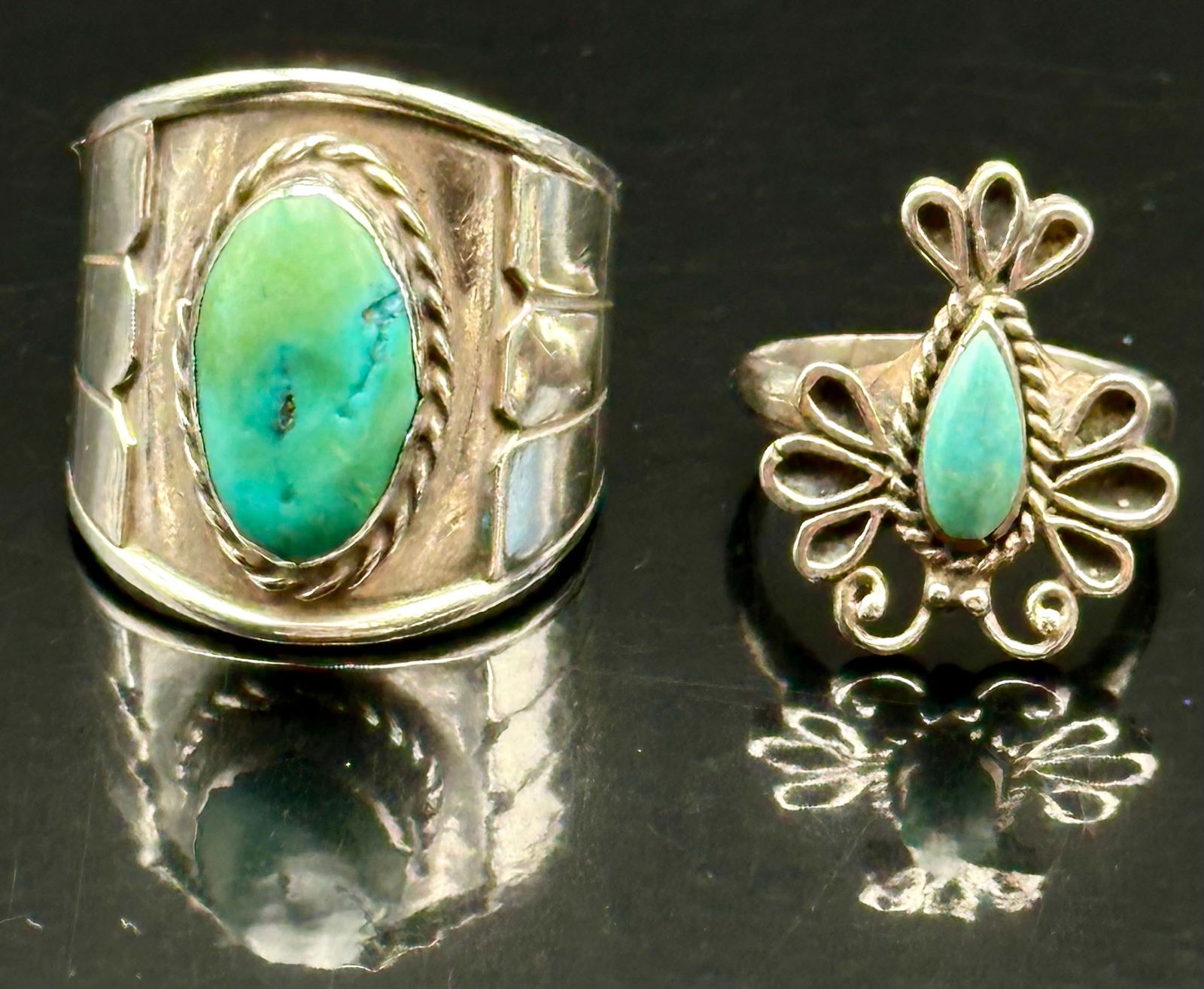 2 Sterling Silver Turquoise Rings – Marked STERLING & BJ – 18g: Lot of two vintage sterling silver turquoise rings.• Both pieces are marked STERLING, one additionally stamped BJ.• Natural turquoise cabochons in classic Navajo-style rope and wirework sett