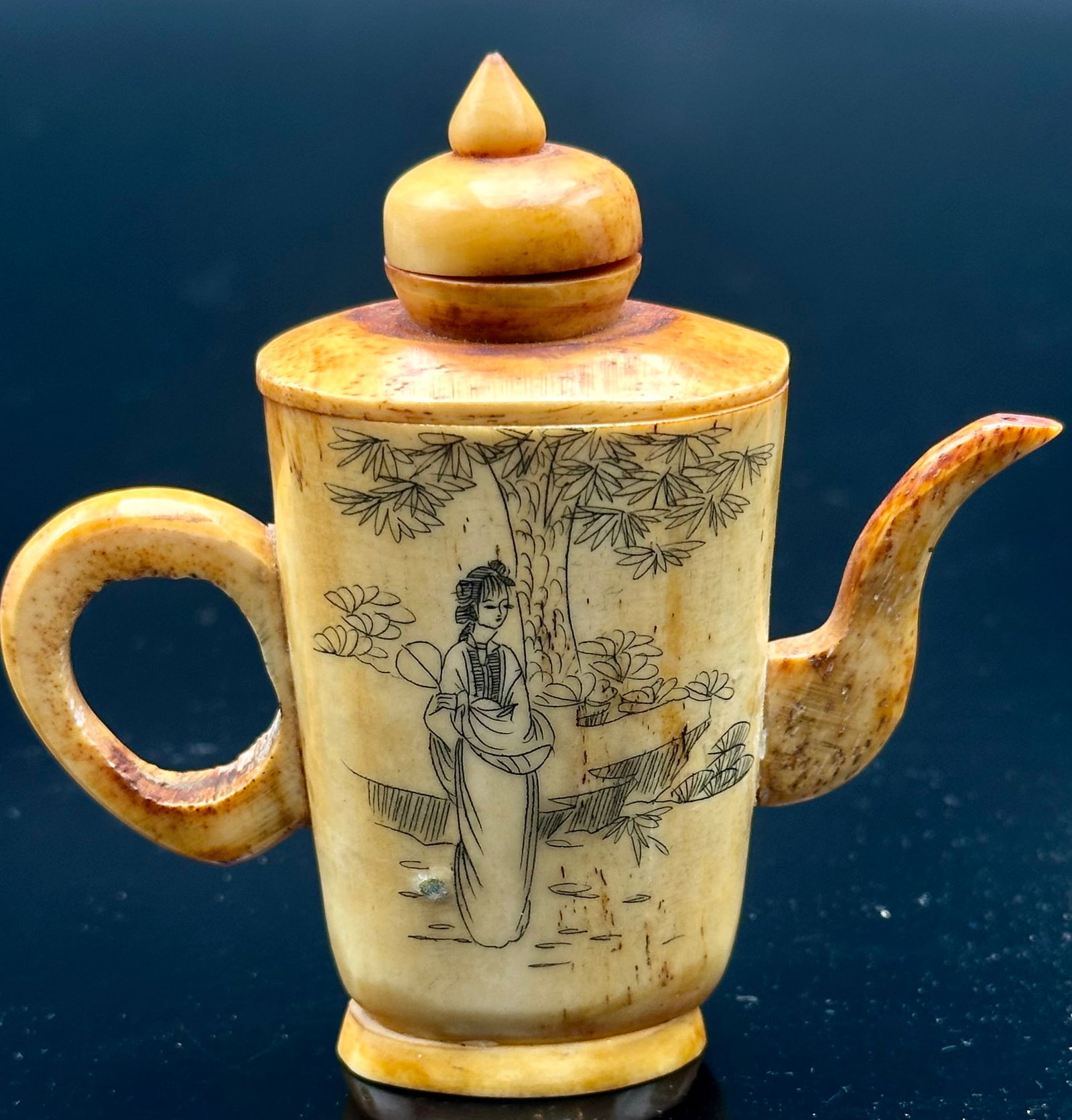 Vintage Chinese Carved Bone Miniature Teapot – Hand-Etched Figures: Beautiful hand-carved bone miniature teapot with etched Asian figures on both sides. The piece shows age patina and natural grain from the bone. Carved spout, handle, and lid all match. Inside is holl