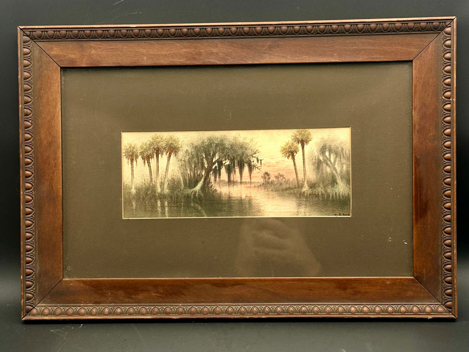 Vintage E.S. Orr Hand-Colored Swamp Landscape Print: Vintage early 1900s hand-colored print by E. S. Orr, featuring a misty Southern swamp landscape with palmetto trees and hanging moss. Signed lower right. Housed in the original carved wood frame with