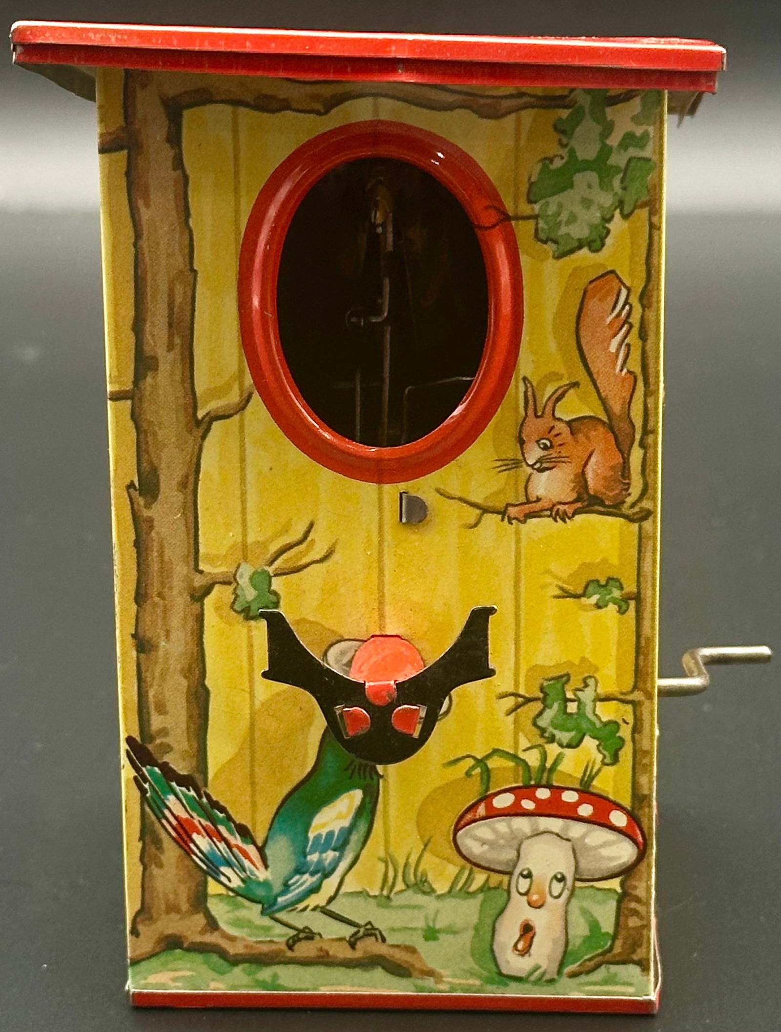 Spardose mit Mechanik, Blech, Deutschland: The item is a mechanical bank, operated by placing a coin in a holder and turning a crank on the side. These banks were manufactured in Germany, with both vintage versions (some dating back to the 195