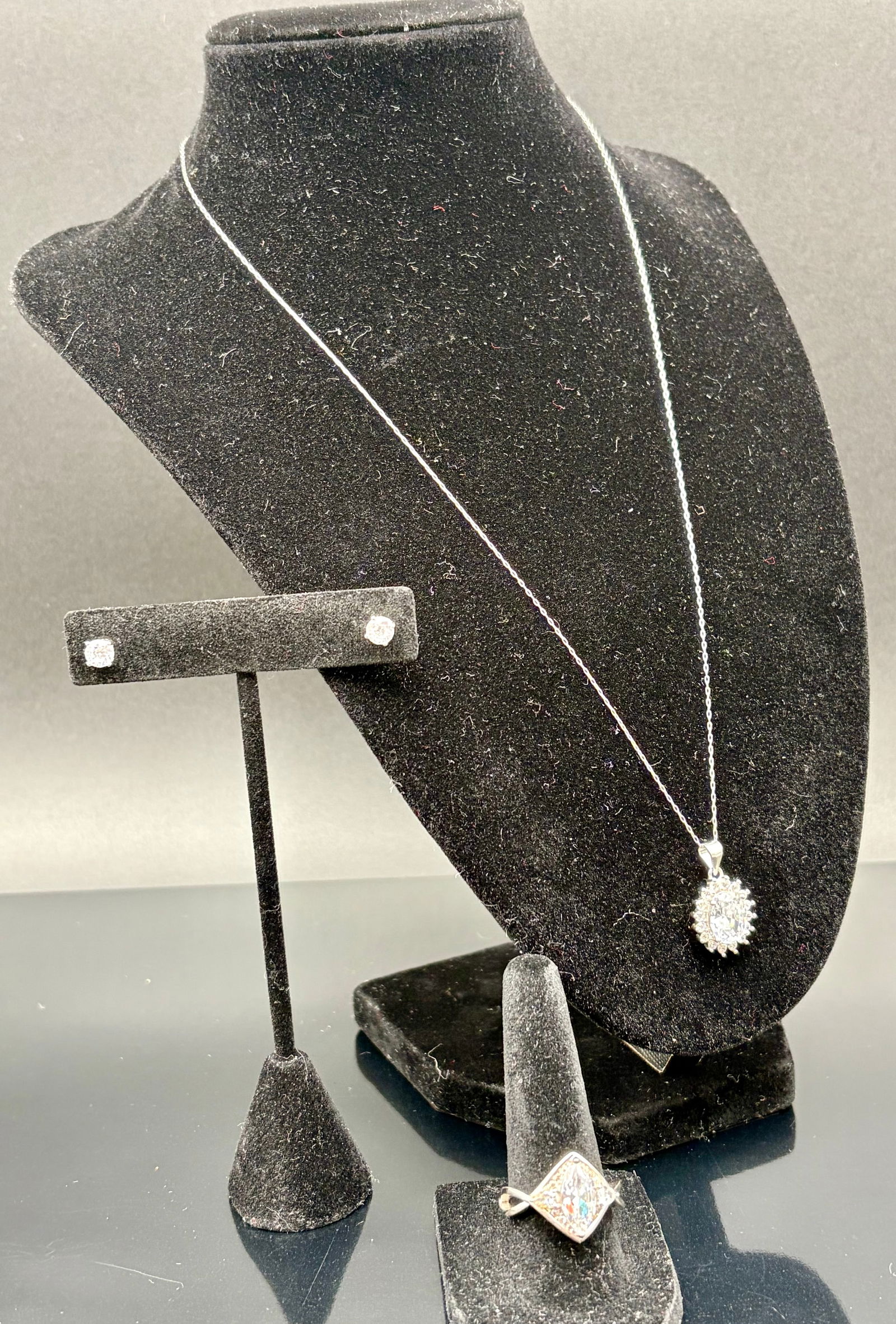 Sterling Silver Necklace, Ring & Earrings Set: Elegant three-piece sterling silver jewelry set featuring a finely detailed pendant necklace, matching stud earrings, and a coordinating ring. The pendant showcases an ornate floral cluster design sus