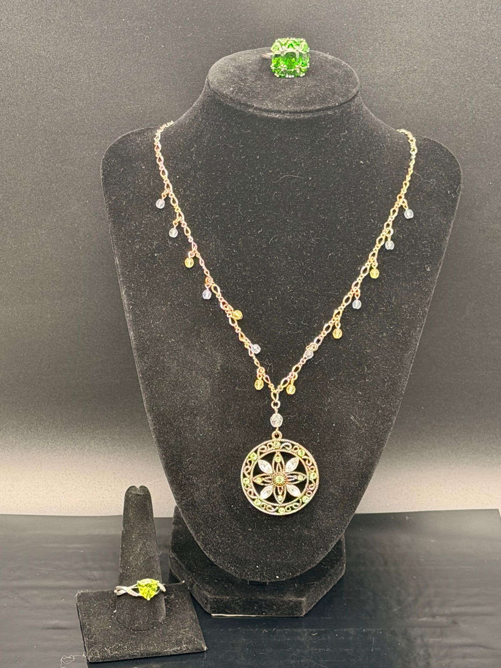 Sterling Silver Green Crystal Pendant Necklace & Matching Rings – 925 Set: Beautiful 925 sterling silver jewelry set featuring an ornate filigree pendant necklace with dangling accent beads and two matching green stone rings. The necklace showcases a circular floral medallio