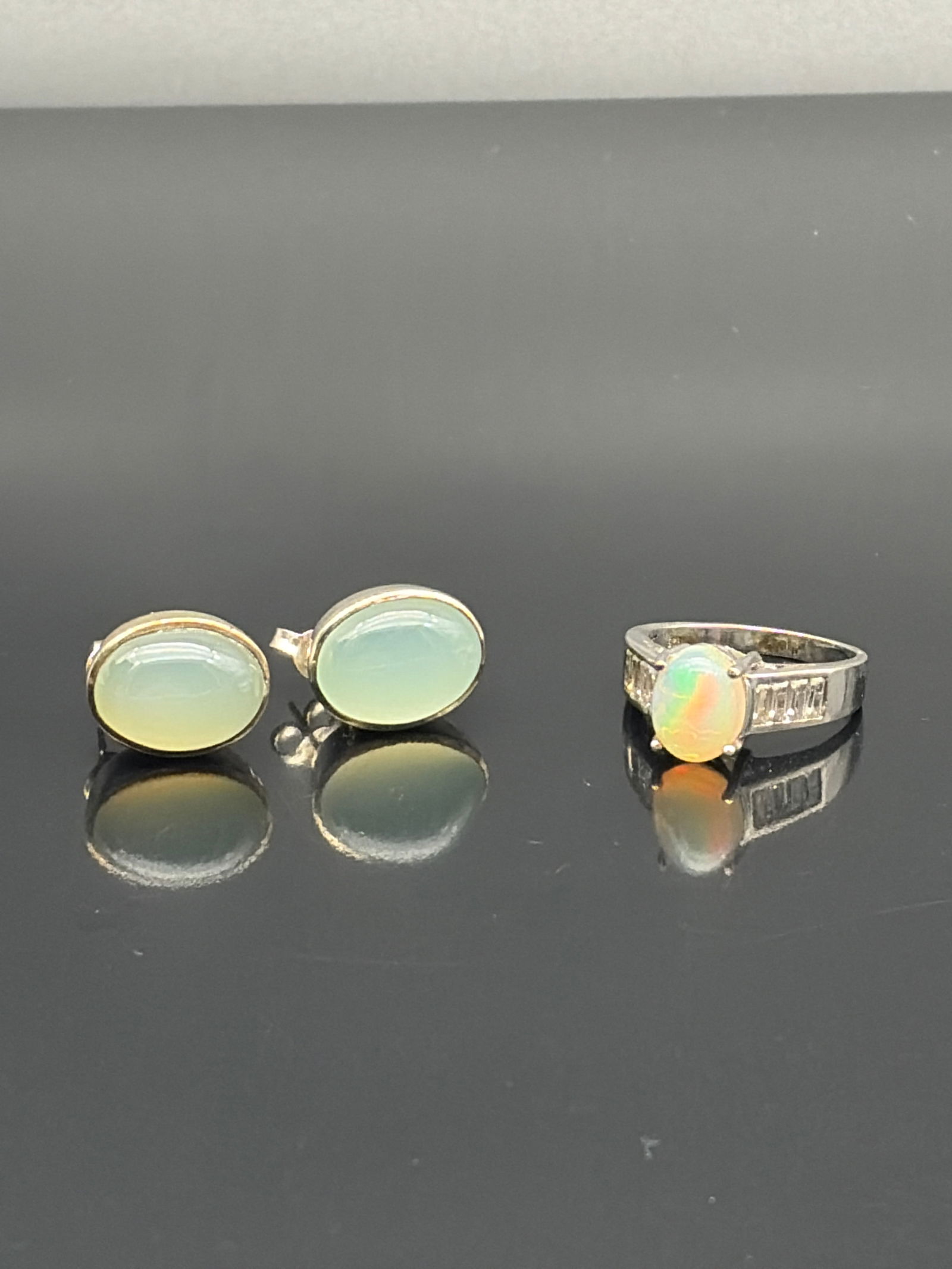 Opal-Style Ring & Oval Cabochon Earrings: Elegant three-piece lot featuring luminous cabochon stones. The set includes a pair of oval stud earrings with soft, milky opalescent cabochons set in simple bezel frames, offering a refined and under