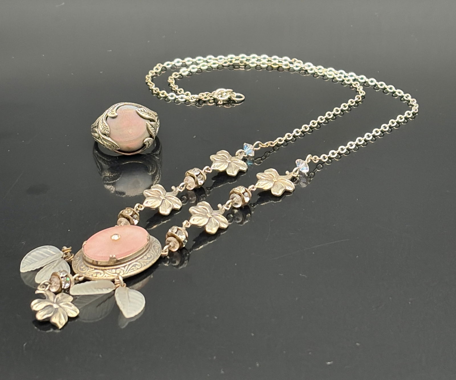 Art Nouveau Pink Stone Floral Necklace & Ring Set: Charming vintage-inspired jewelry set featuring a decorative necklace and matching ring, both centered with a soft pink cabochon stone. The necklace showcases intricate Art Nouveau–style metalwork a