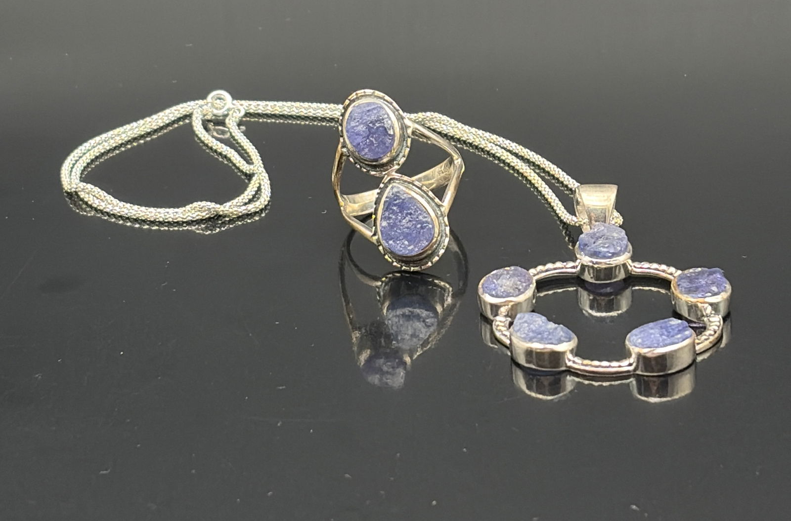 Blue Stone Sterling Pendant & Double-Stone Ring Set: Contemporary handcrafted jewelry set featuring a circular pendant and a coordinating ring, each set with textured blue cabochon stones resembling sodalite or lapis in rustic, bezel-style mounts. The p