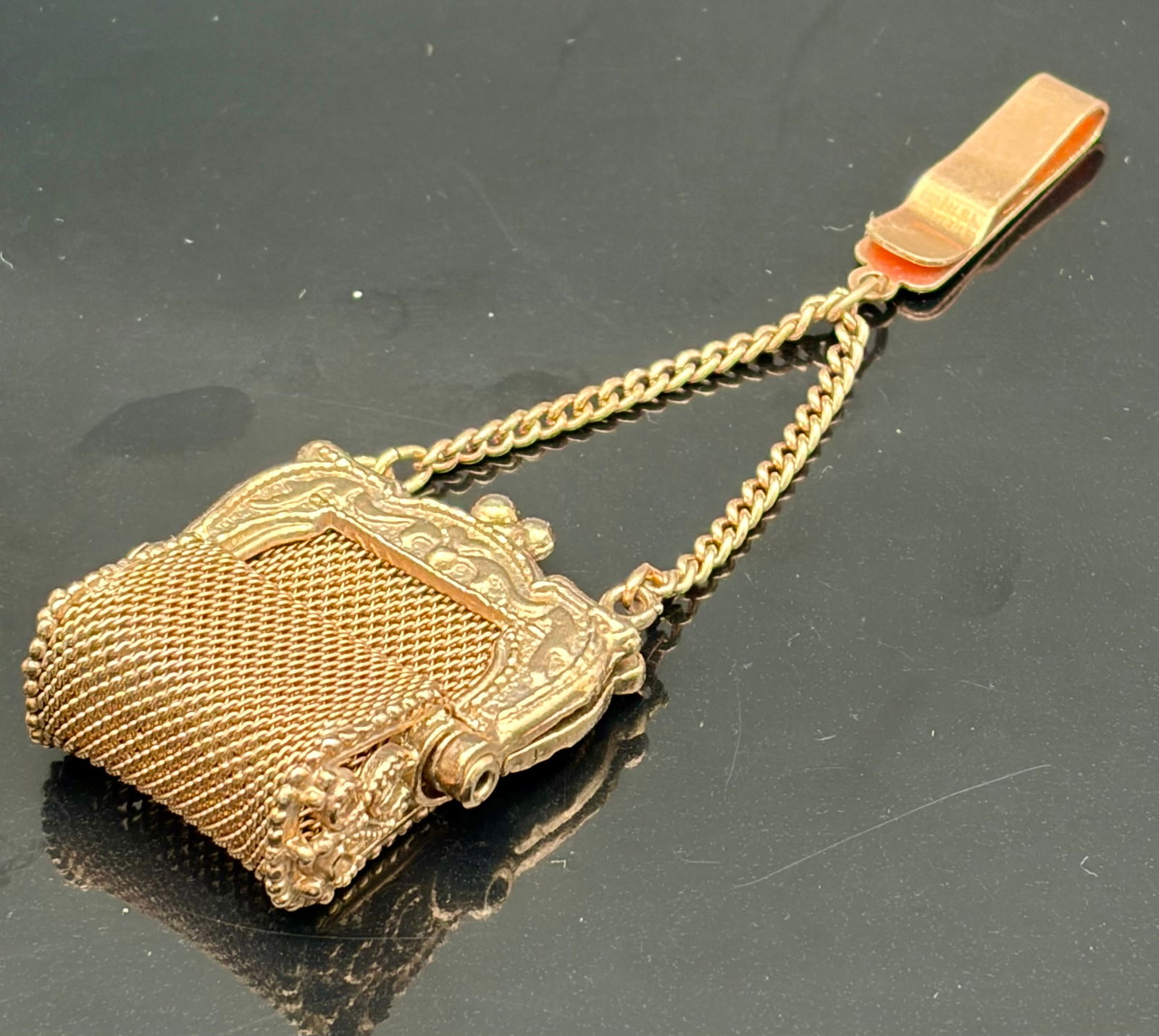 Vintage Gold-Tone Mesh Chatelaine Purse Pendant: Charming vintage purse-form pendant designed in the style of early 20th-century chatelaine accessories. Crafted in a warm gold-tone finish, it features an ornate repoussé frame, double suspension cha