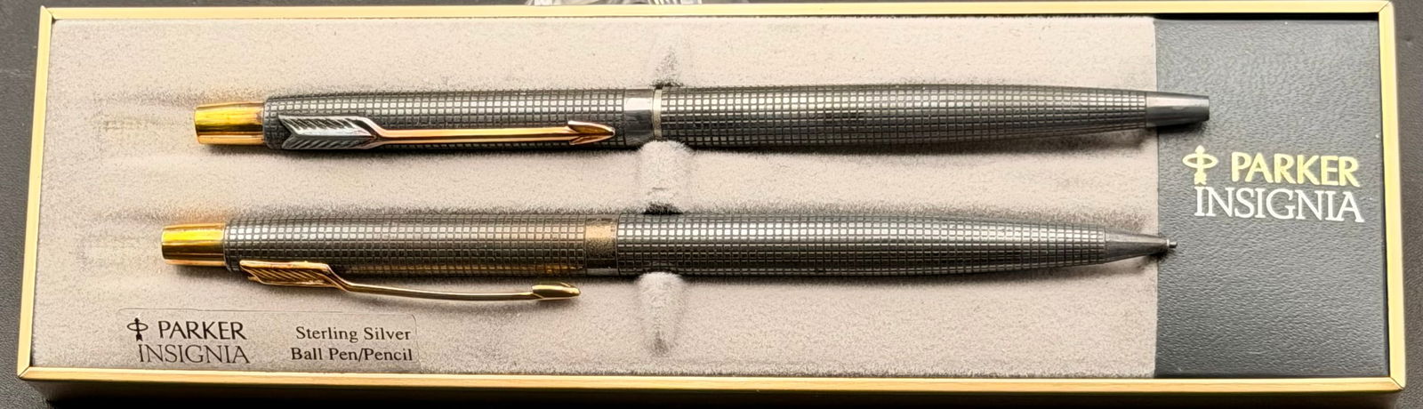 Parker Insignia Sterling Silver Ballpoint Pen & Pencil Set – Original Box – Gold Trim: Elegant Parker Insignia matching sterling silver ballpoint pen and mechanical pencil set, presented in the original Parker display box. Both pieces feature the classic sterling silver grid pattern wit