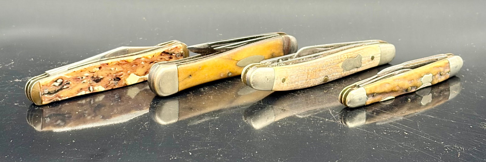 4 Vintage Jack Knives incl. Iroquois USA: A handsome lot of four vintage American-style jack knives, featuring jigged composite and bone-style handles in warm earth tones. This group includes:1.Iroquois – Made in USAMarked “IROQUOIS – M