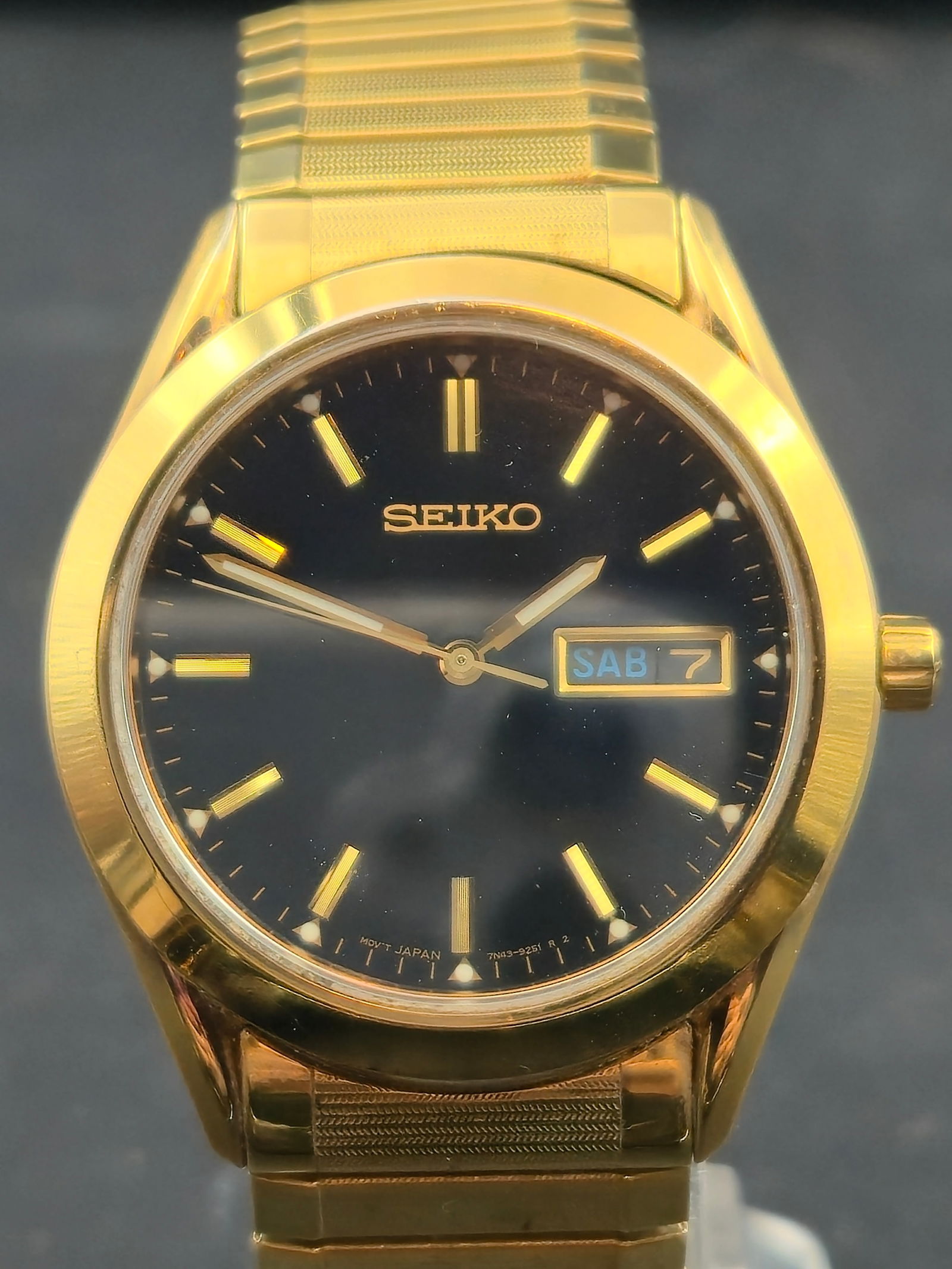 1990s Seiko 7N43-9070 Gold-Tone 38mm Black Dial Day-Date Quartz Watch Running & Keeping Time: Classic 1990s Seiko 7N43-9070 gold-tone men’s quartz watch featuring a glossy black dial with gold baton markers and matching gold hands. Includes Spanish/English day-date window. The watch is runni