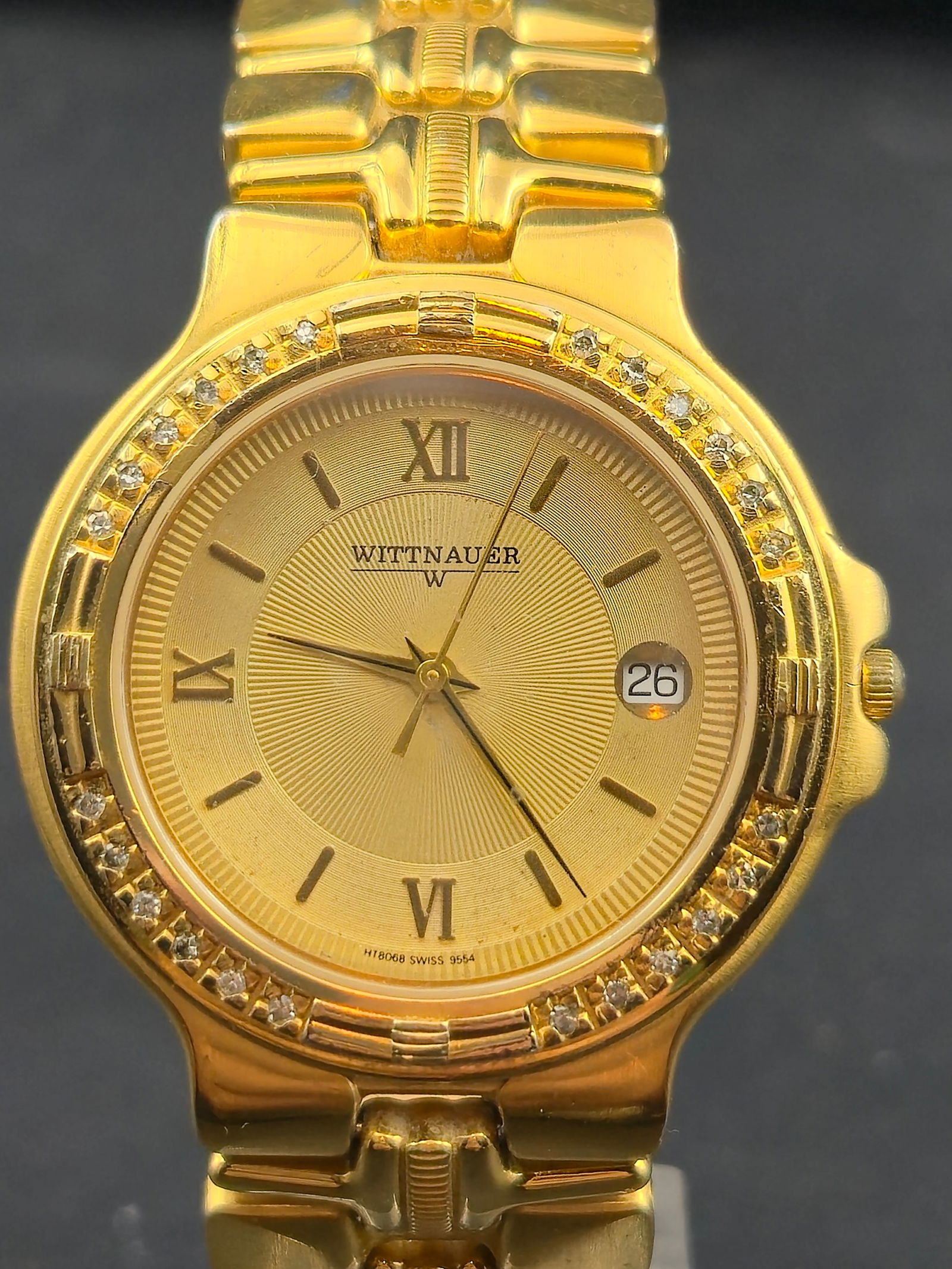 Wittnauer H18068 35mm Gold-Tone Diamond Bezel Swiss Quartz Watch Date Running & Keeping Time: Elegant Wittnauer H18068 Swiss-made quartz dress watch featuring a gold-tone case with a full diamond-accent bezel and a matching gold sunburst dial with Roman numerals. Includes a framed date window