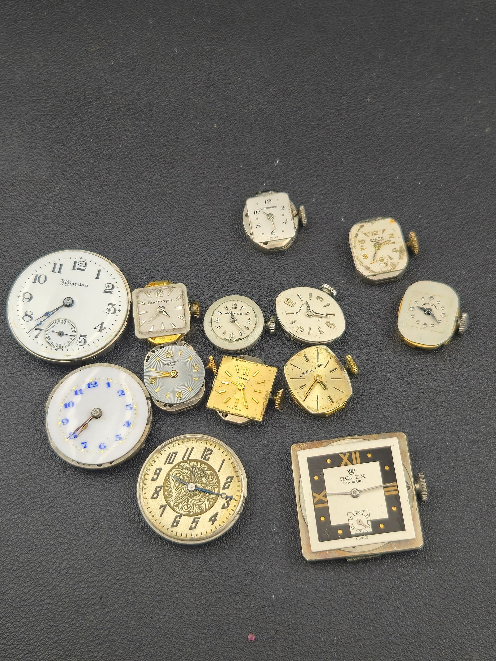 1950s–1970s Lot of 13 Swiss Watch Movements Running Baume Movado Bulova Wittnauer GP: A mixed lot of 13 vintage Swiss watch movements and dials spanning the 1950s–1970s, including premium makers such as Baume & Mercier, Movado, Girard-Perregaux, Bulova, Wittnauer, Juvenia, and others