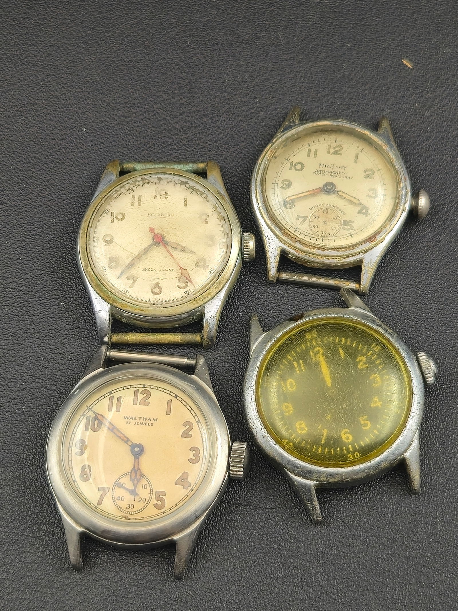 1940s–1950s Military-Style Wristwatch Lot of 4 – Waltham, Military, Helbros – Untested Vintage: Offered is a lot of four vintage military-style wristwatches from the 1940s–1950s, including two Waltham 6/0-size American-made movements and two Swiss-made field watches. These feature classic radi