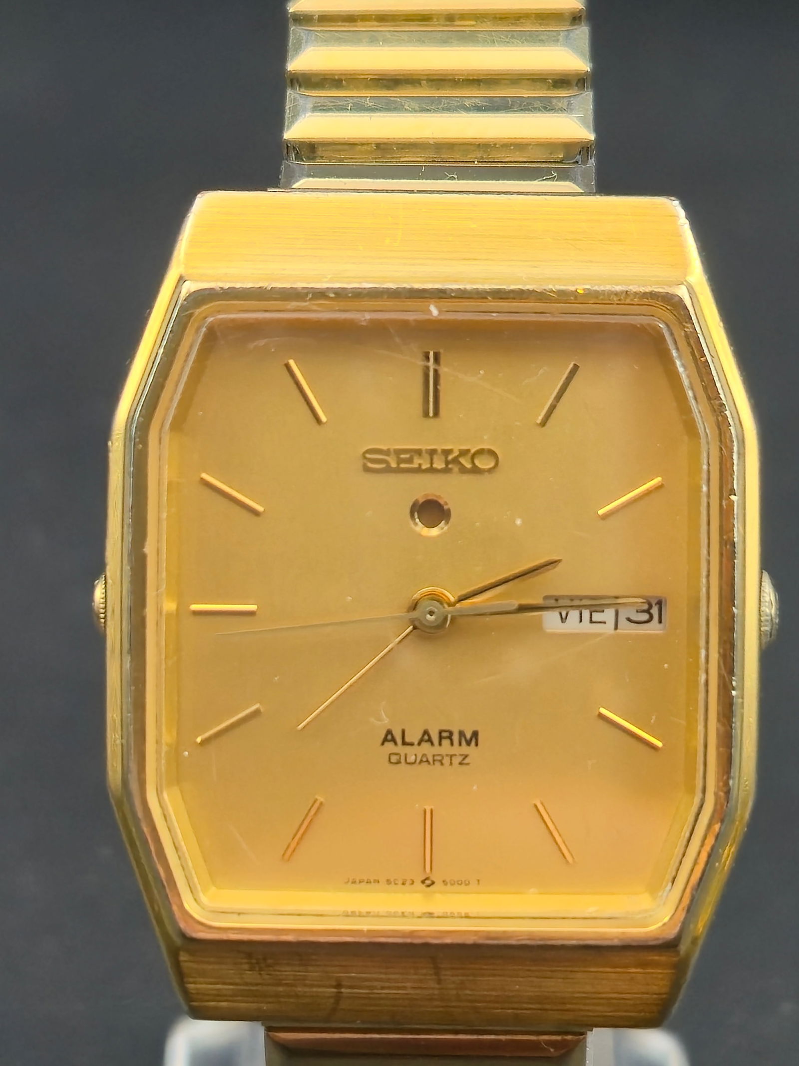 1985 Seiko 5C23-5009 Gold-Tone Alarm Quartz 31mm Vintage Dress Watch – New Battery: vintage mid-1980s Seiko Alarm Quartz wristwatch, reference 5C23-5009, featuring Seiko’s early dual-crown alarm quartz movement. Presented in a gold-tone octagonal case with a matching gold dial and