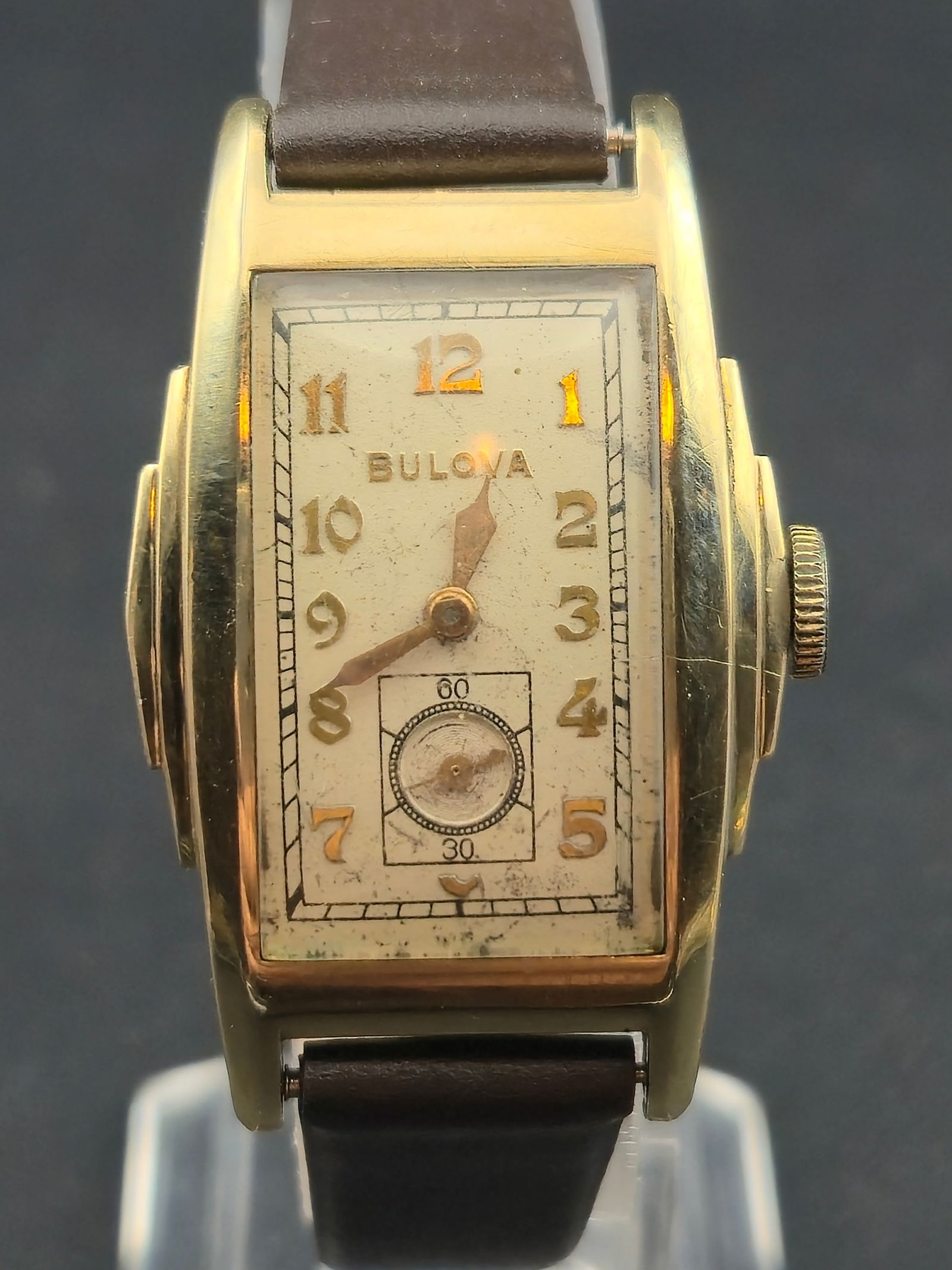 1940 Bulova “Executive” 10K RGP 25mm Tank Watch 15J Cal. 10AX – Running: Beautiful early-1940s Bulova “Executive” tank-style wristwatch featuring a classic curved case, radium numeral dial, and sub-seconds at 6. Powered by Bulova’s 15-jewel Caliber 10AX movement,