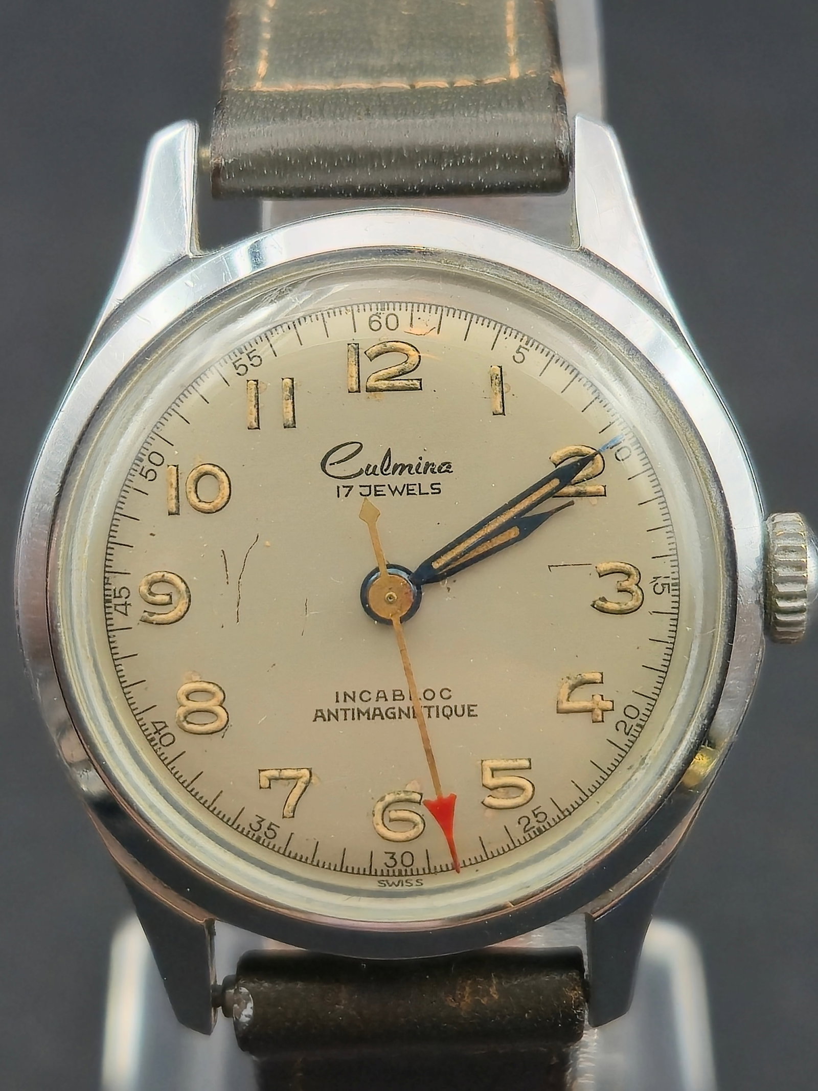 1950s Culmina 17 Jewel 30mm Swiss Incabloc Antimagnetic Watch Runs: Mid-century Culmina Swiss wristwatch featuring a classic military-style dial with luminous numerals, blued hands, and a red sweep seconds pointer. Powered by a 17 jewel Culmina Watch Co. manual moveme