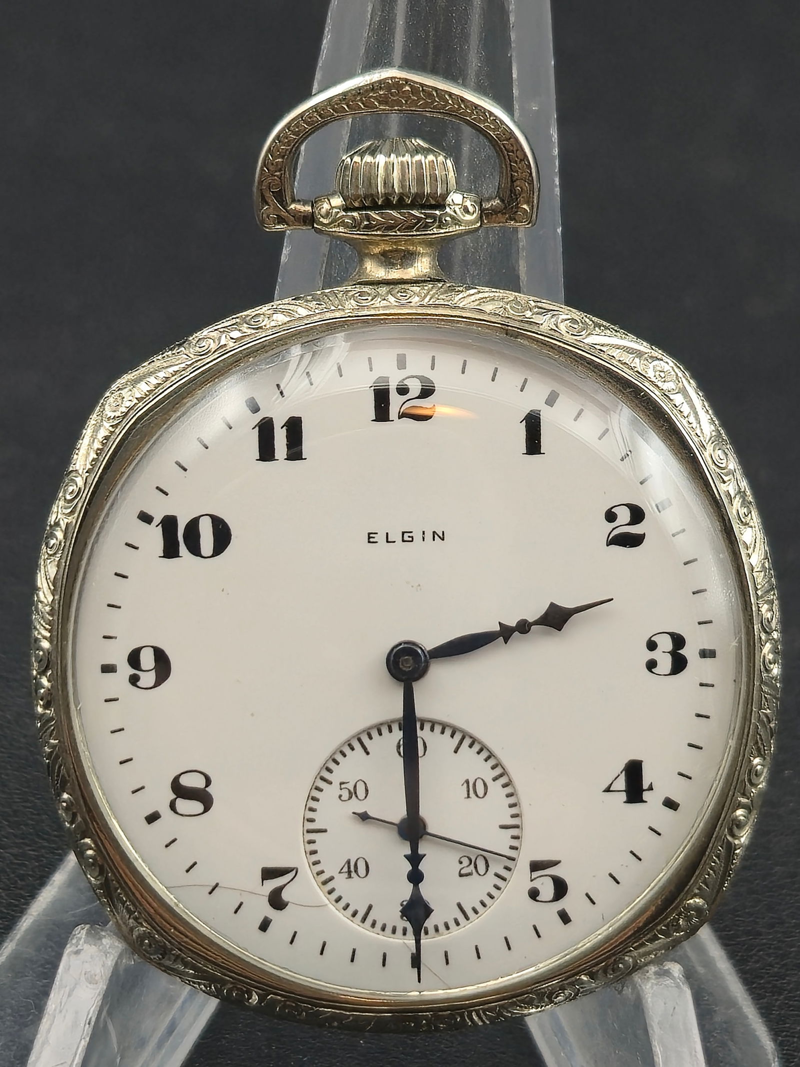 1923 Elgin Grade 303 12s 7J Pocket Watch – Officer’s Arabic Dial – Fancy Supreme Case – Runs: A 1923 Elgin Grade 303 pocket watch housed in a beautifully engraved Supreme I.W.C.Co. case, featuring ornate Art Deco relief work along the bezel, bow, and edge. The back displays vertical engine-tur
