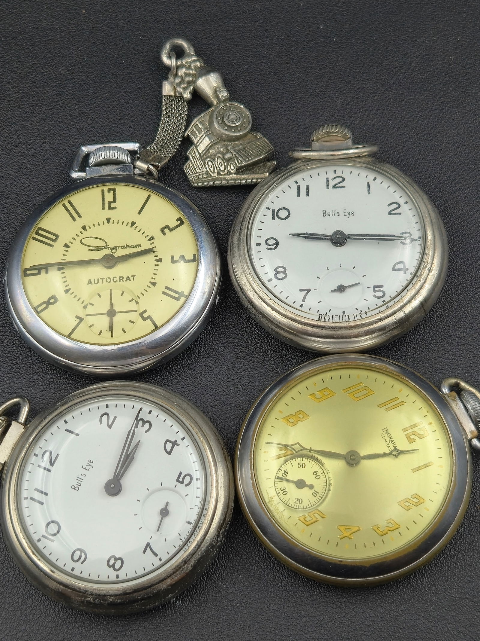 Lot of 4 Vintage Pocket Watches, Ingraham Autocrat, Bull’s Eye Dials, Train Fob, Running: Lot of four vintage pocket watches offered together. This group includes an Ingraham Autocrat, two Bull’s Eye–signed pocket watches, and an additional vintage pocket watch, accompanied by a decora