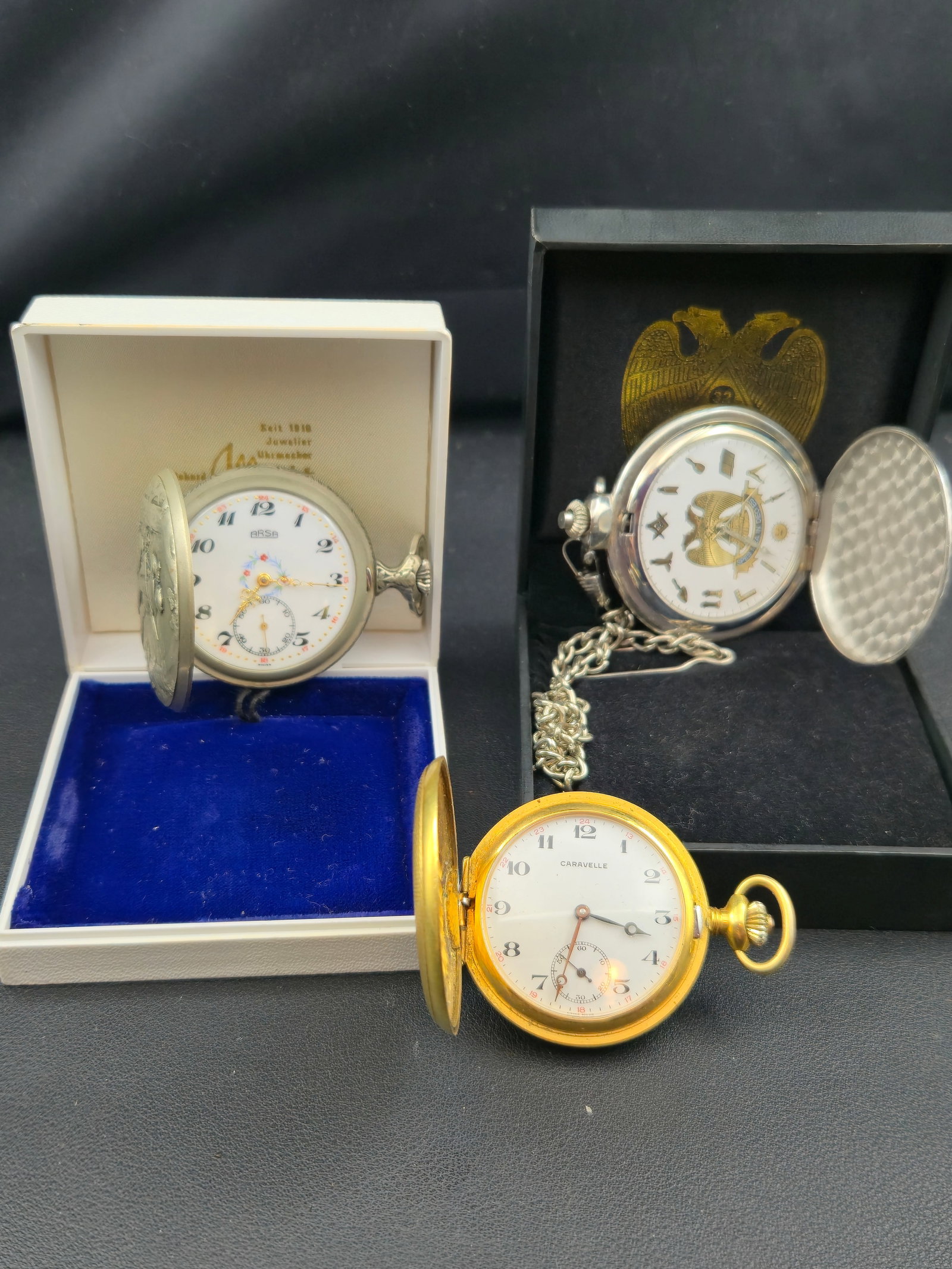Lot of 3 Pocket Watches ARSA Caravelle Masonic Hunter Silver Tone Running: Lot of three pocket watches, including an ARSA Swiss mechanical pocket watch with original box, a Caravelle Swiss Made pocket watch in a gold-tone hunter case, and a silver-tone Masonic themed pocket