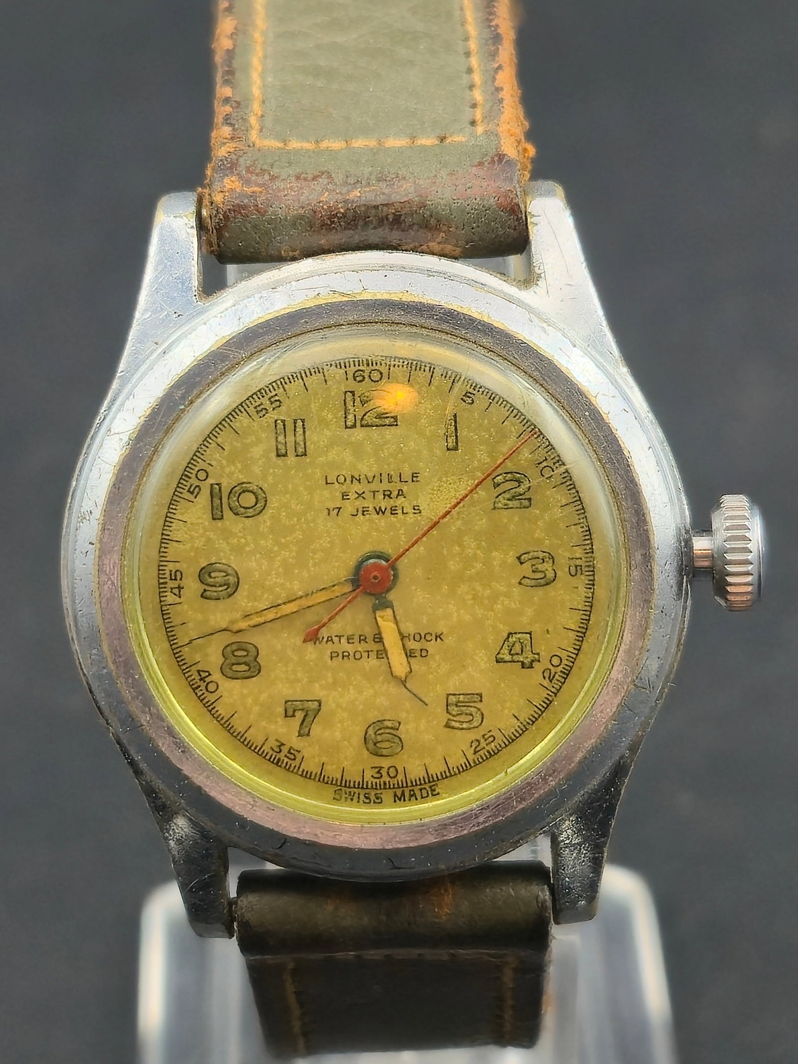Vintage Lonville Extra Swiss 17J Manual Wind Wristwatch 30.6mm Steel Back Running: Vintage Swiss wristwatch by Lonville Watch Co., featuring a compact stainless steel–back case and a yellow-toned dial with bold Arabic numerals. The watch is powered by a 17-jewel Swiss manual-wind 