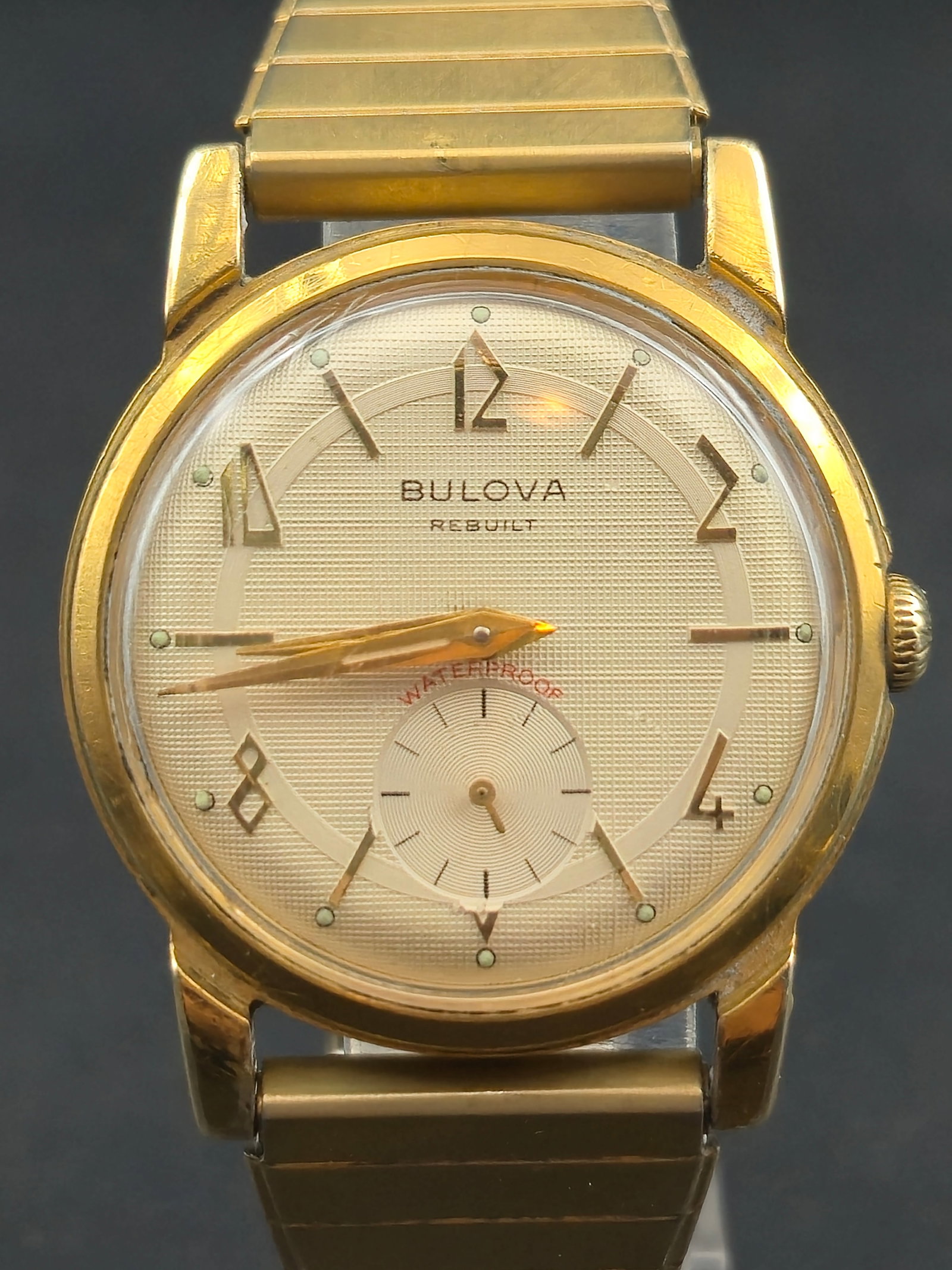 Bulova Rebuilt Swiss Manual Wind Small Seconds c.1950s 32.7mm Gold-Tone Runs: Vintage Bulova Swiss manual-wind wristwatch featuring a textured champagne dial with applied gold Arabic numerals, faceted markers, and small seconds at 6 o’clock. Dial signed “Bulova Rebuilt&rdqu