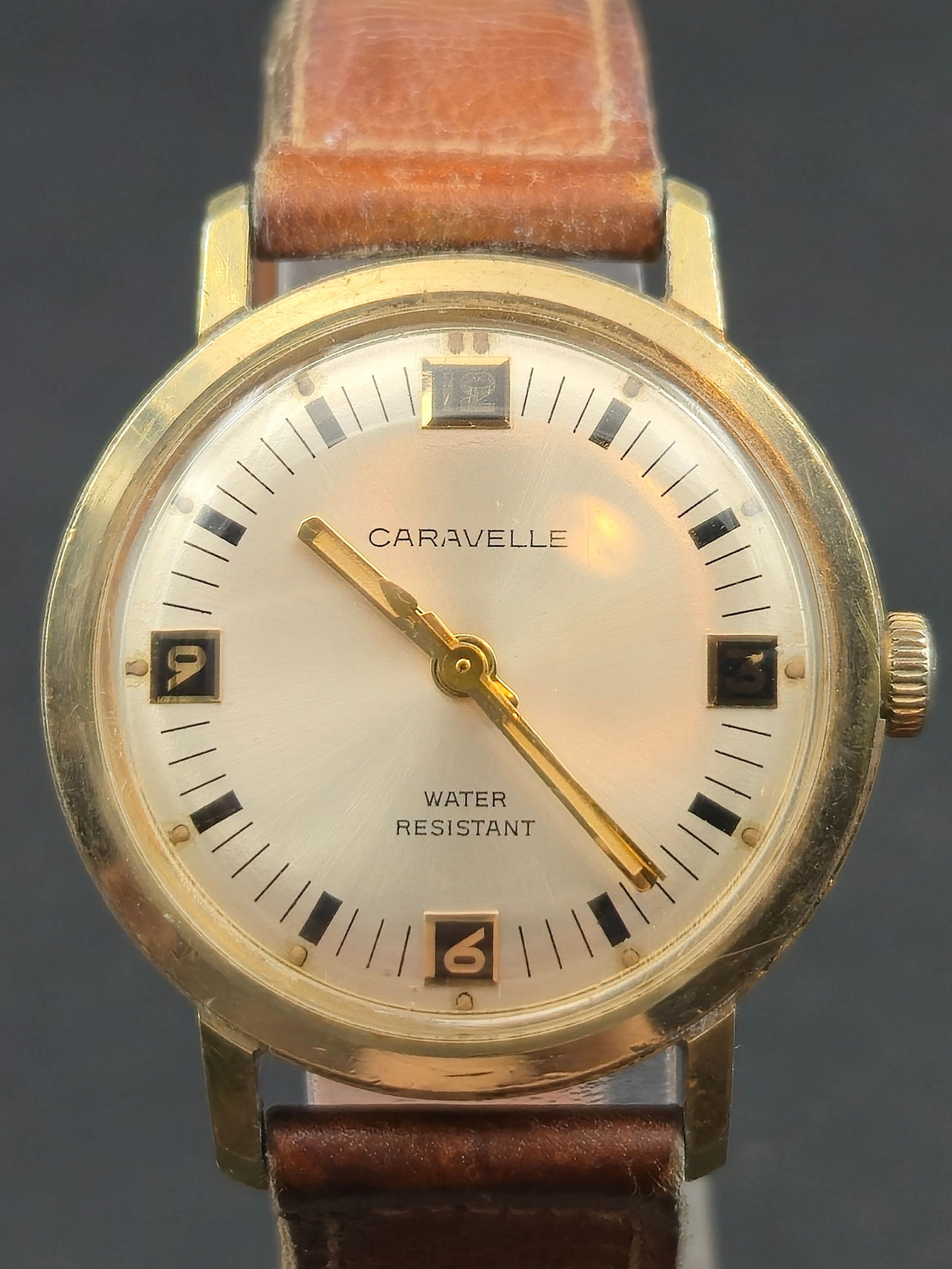 Caravelle by Bulova Vintage Dress Watch c.1960s 31.5mm Manual Wind 7J Runs: Vintage Caravelle by Bulova dress wristwatch from the 1960s featuring a clean silver sunburst dial with applied black square hour markers and gold-tone baton hands. Dial signed Caravelle with Water Re