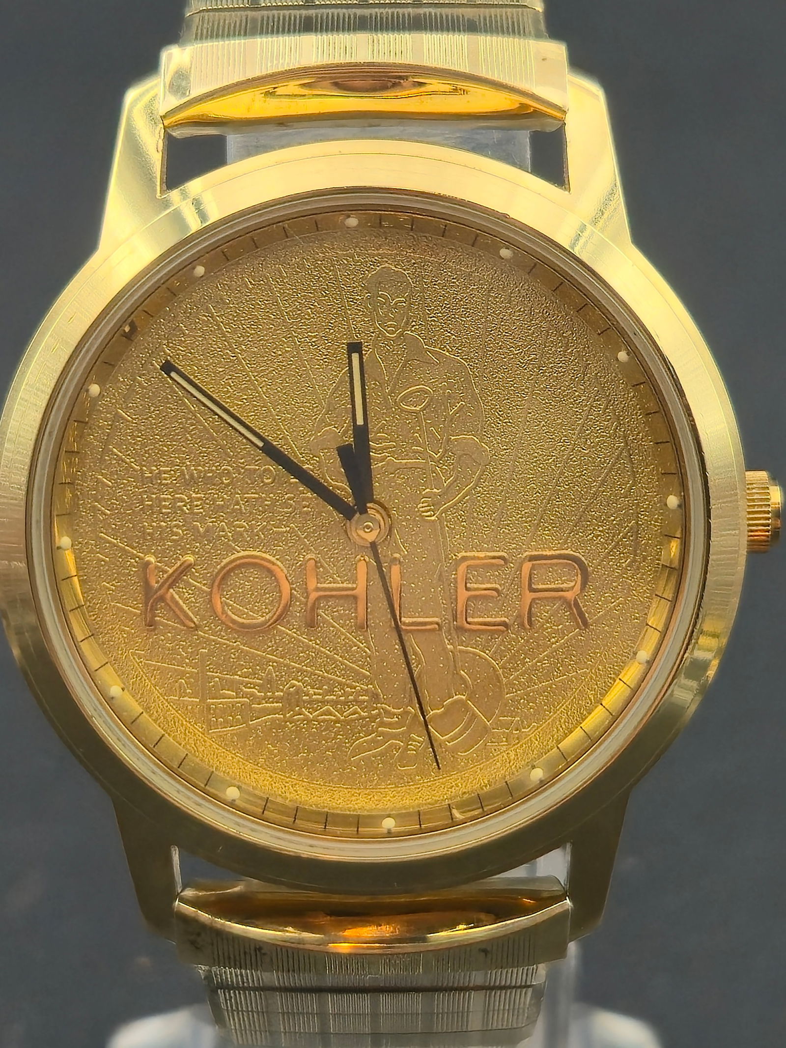 Kohler Presentation Quartz Watch Gold Tone Case 35.13mm GF Expansion Band Montreux Box Runs: Corporate presentation Kohler wristwatch featuring a gold-tone dial with engraved industrial worker motif and prominent KOHLER signature. Gold-tone round case fitted with a gold-filled expansion brace